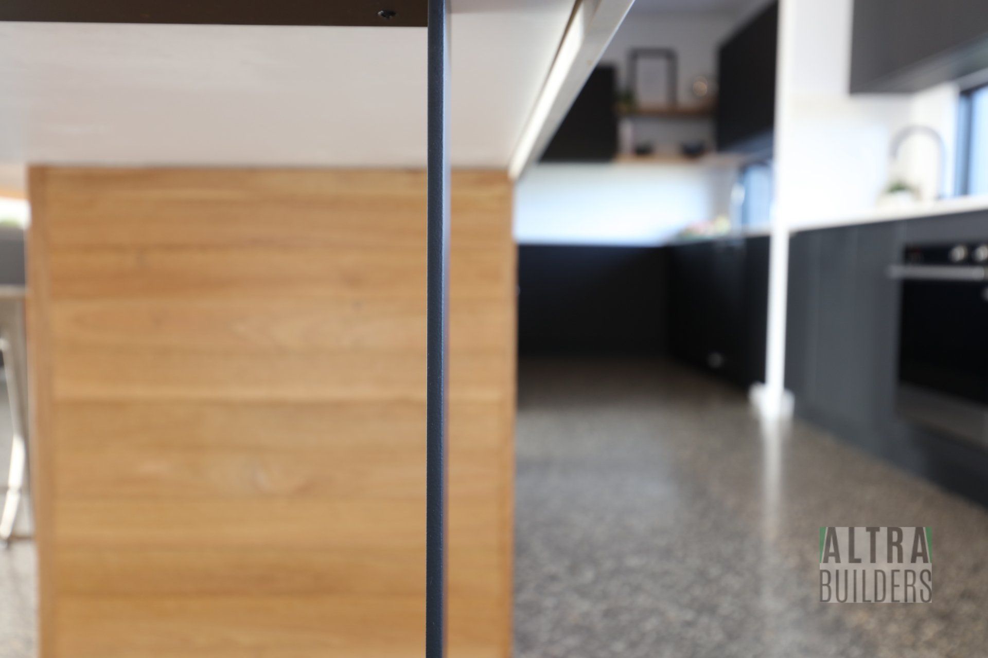 A kitchen with a wooden island and black cabinets