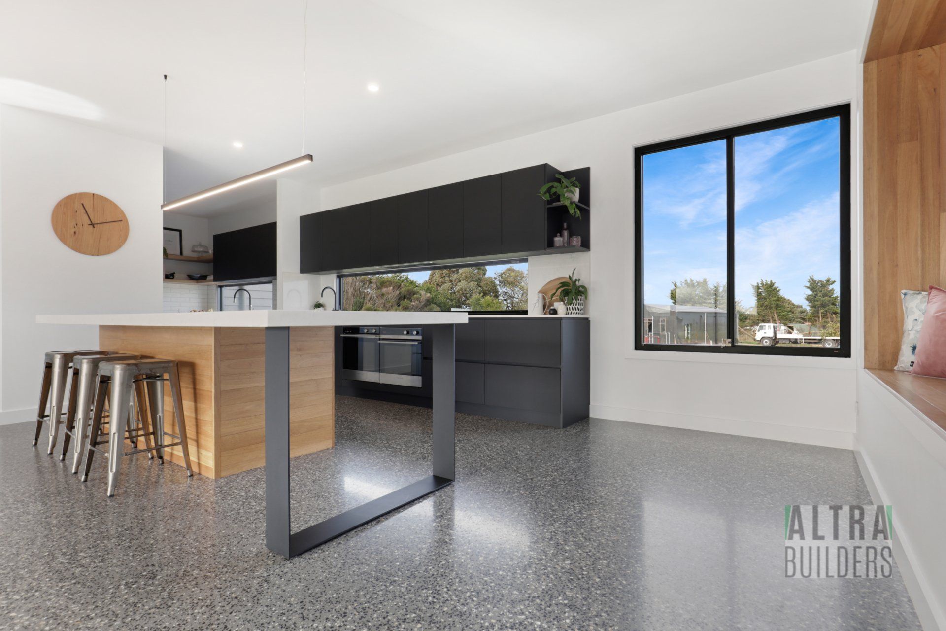 A kitchen with a large island and a clock on the wall.