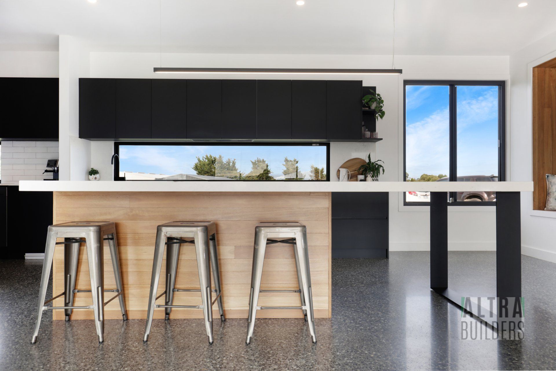 A kitchen with a large island and stools