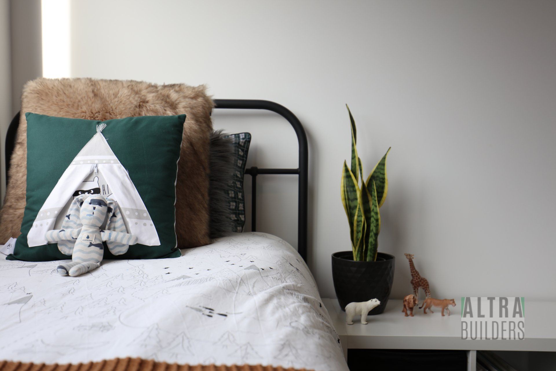 A bed with a green pillow that says a on it