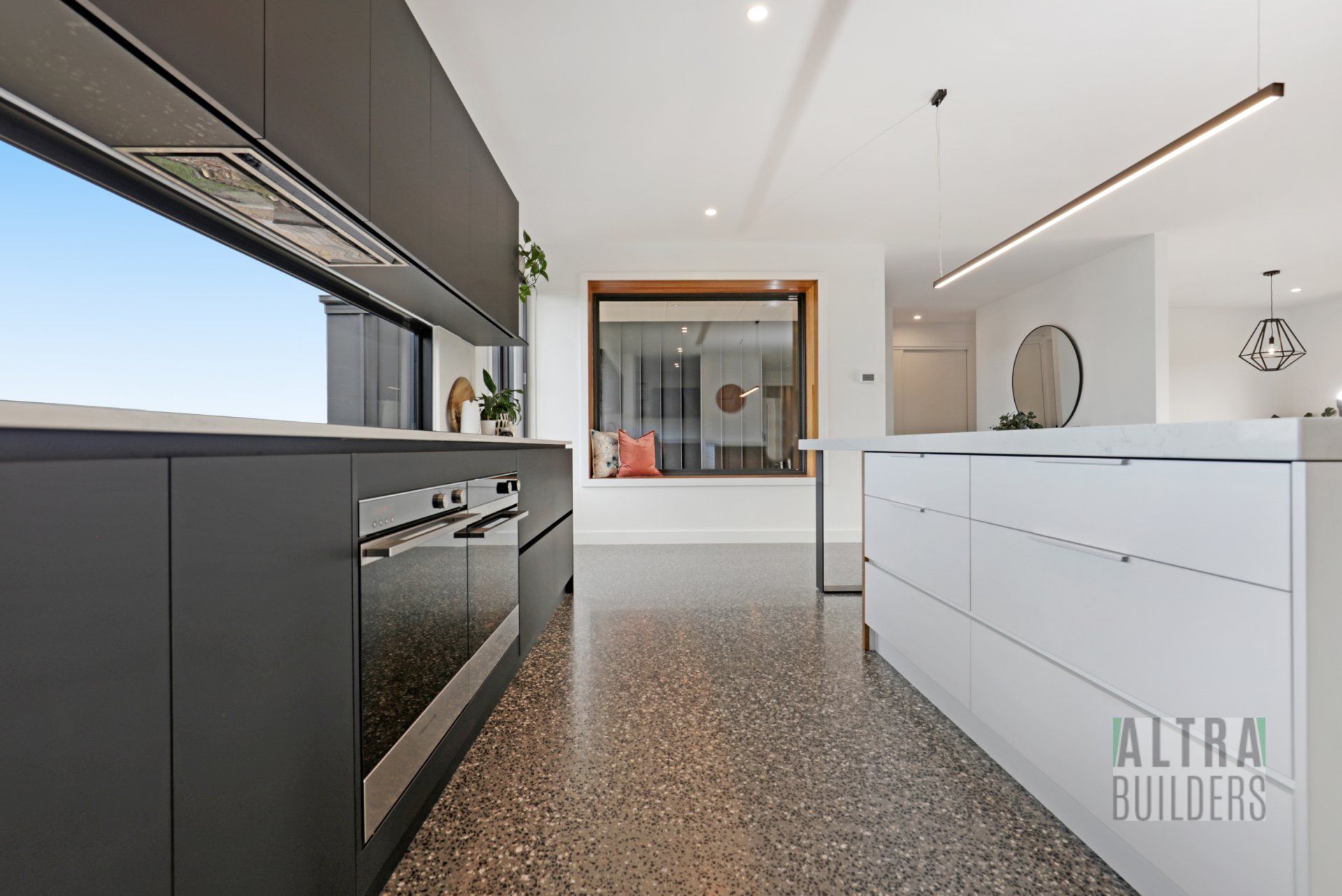 A kitchen with a large island and a large window