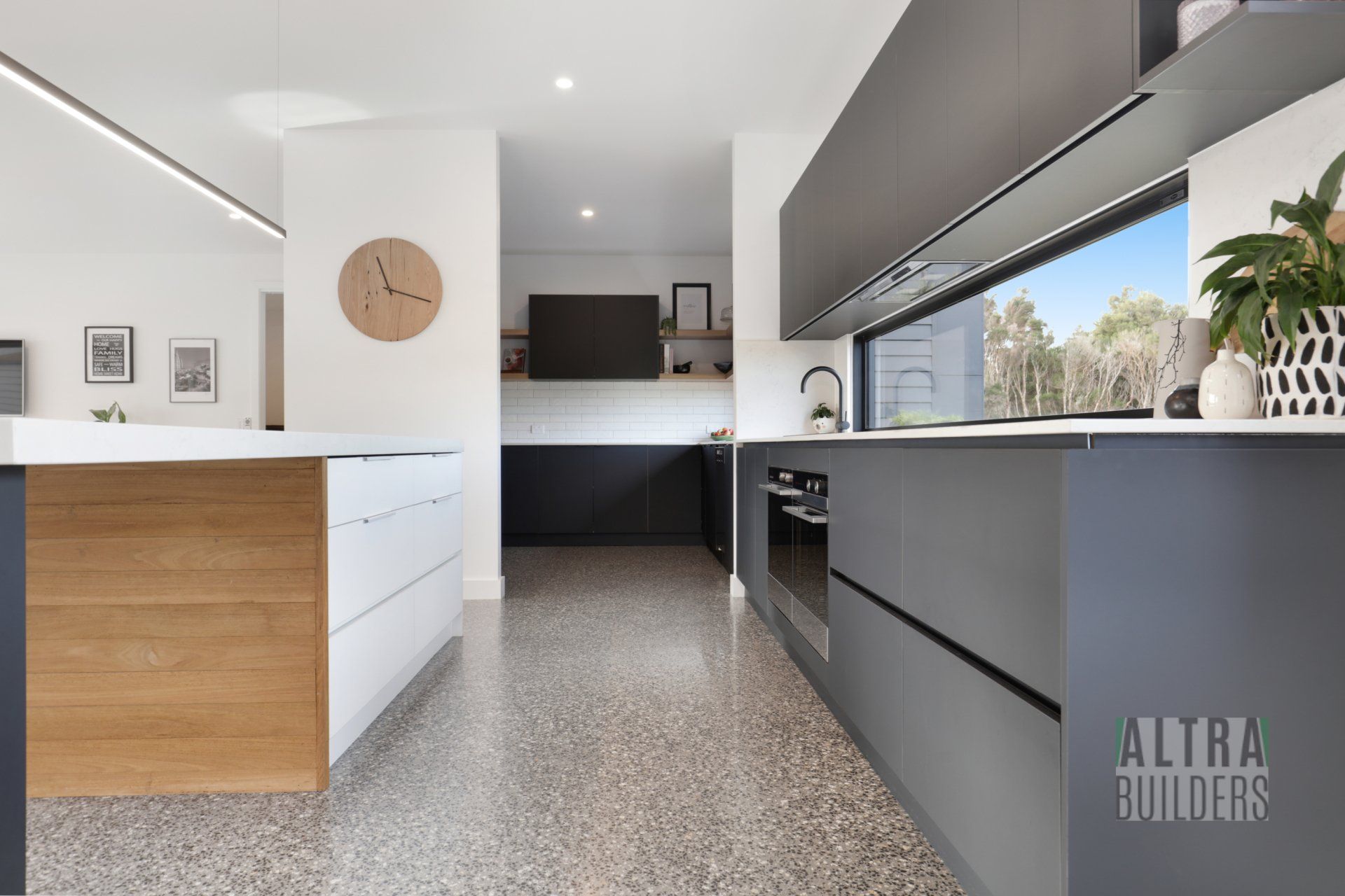 A kitchen with a large window and a clock on the wall.