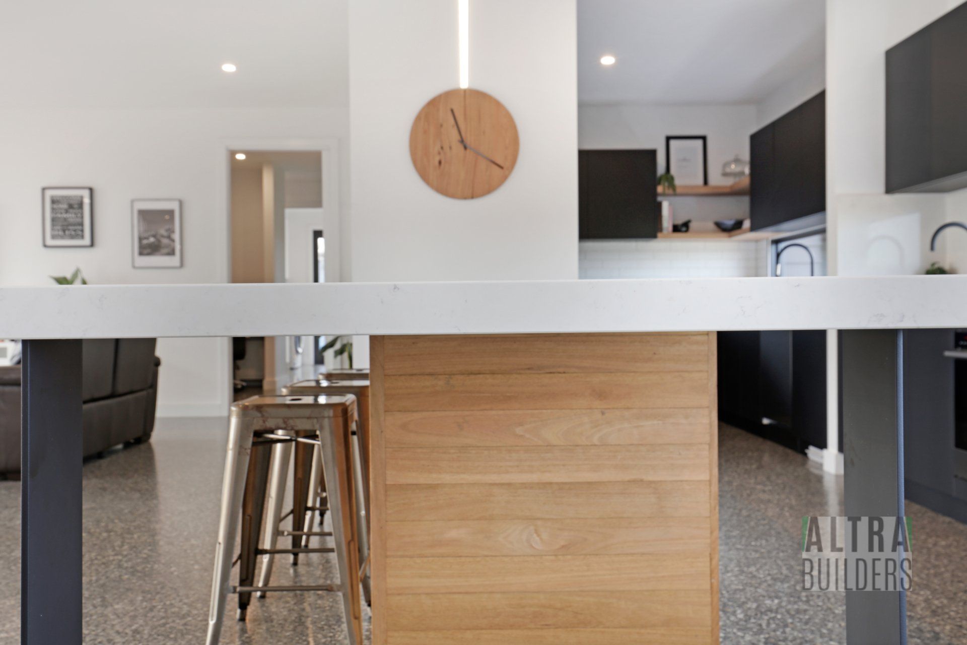 A kitchen with a wooden island and a clock on the wall