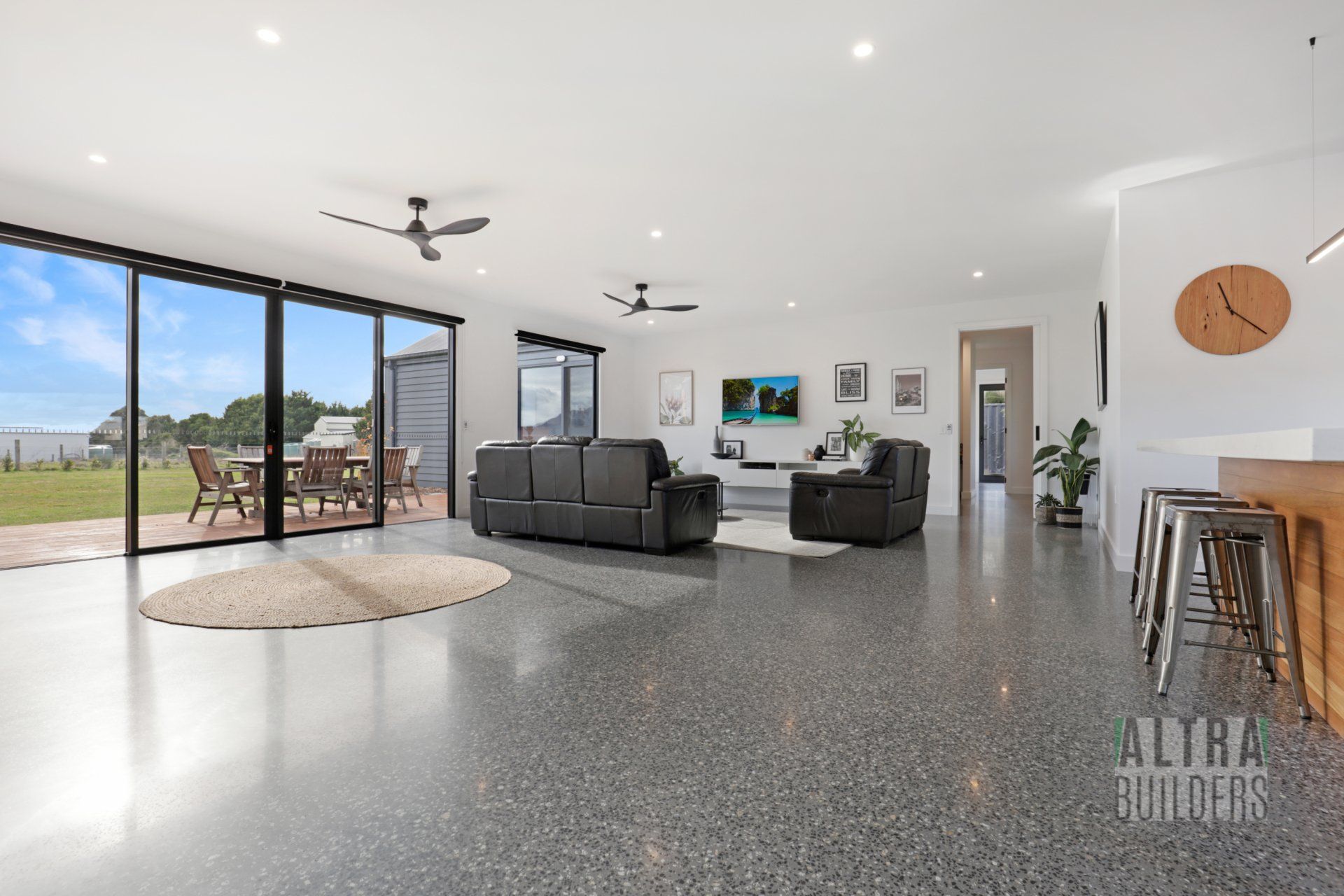 A living room with a couch and a clock on the wall