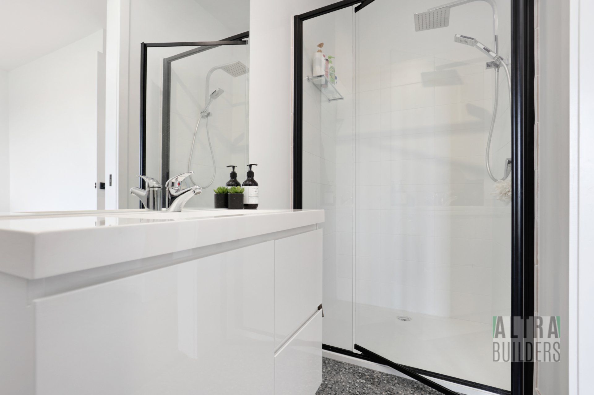 A bathroom with a sink , mirror and shower.