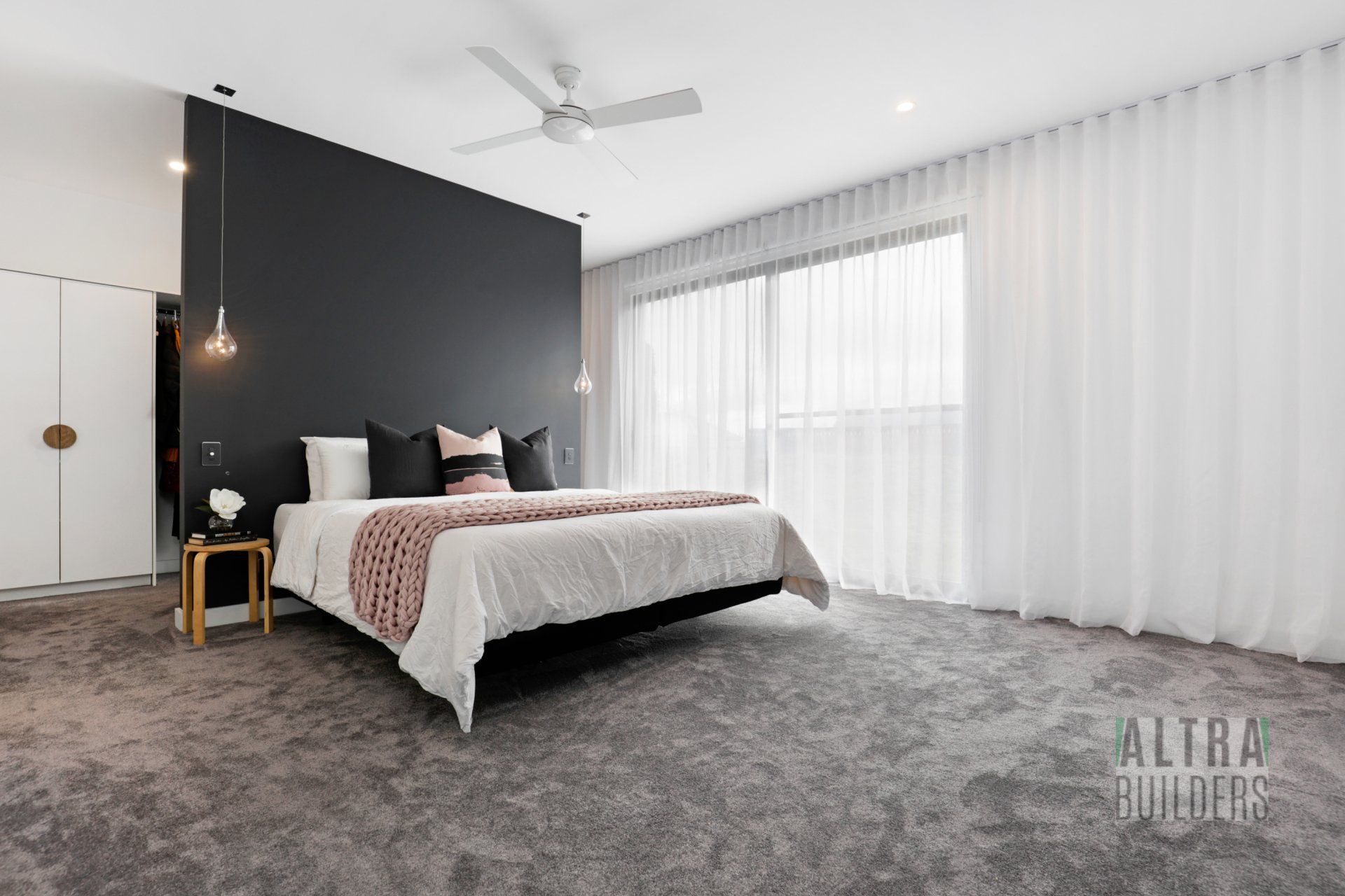 A bedroom with a large bed and a ceiling fan.