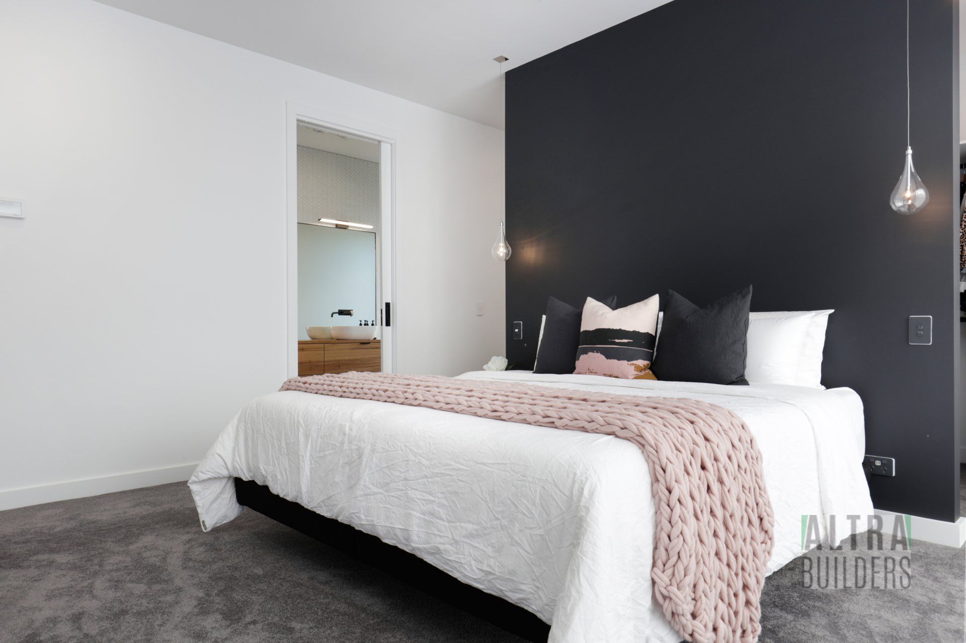 A bedroom with a large bed and a black wall