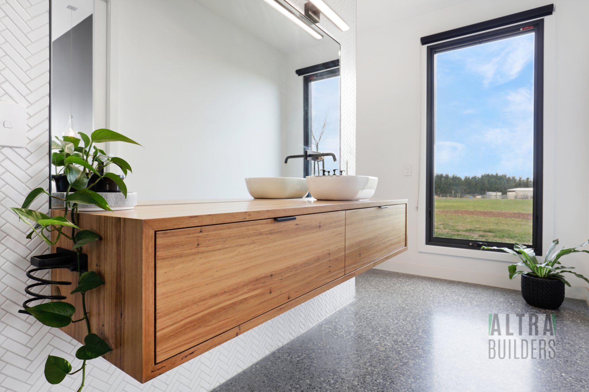 A bathroom with two sinks and a large mirror.