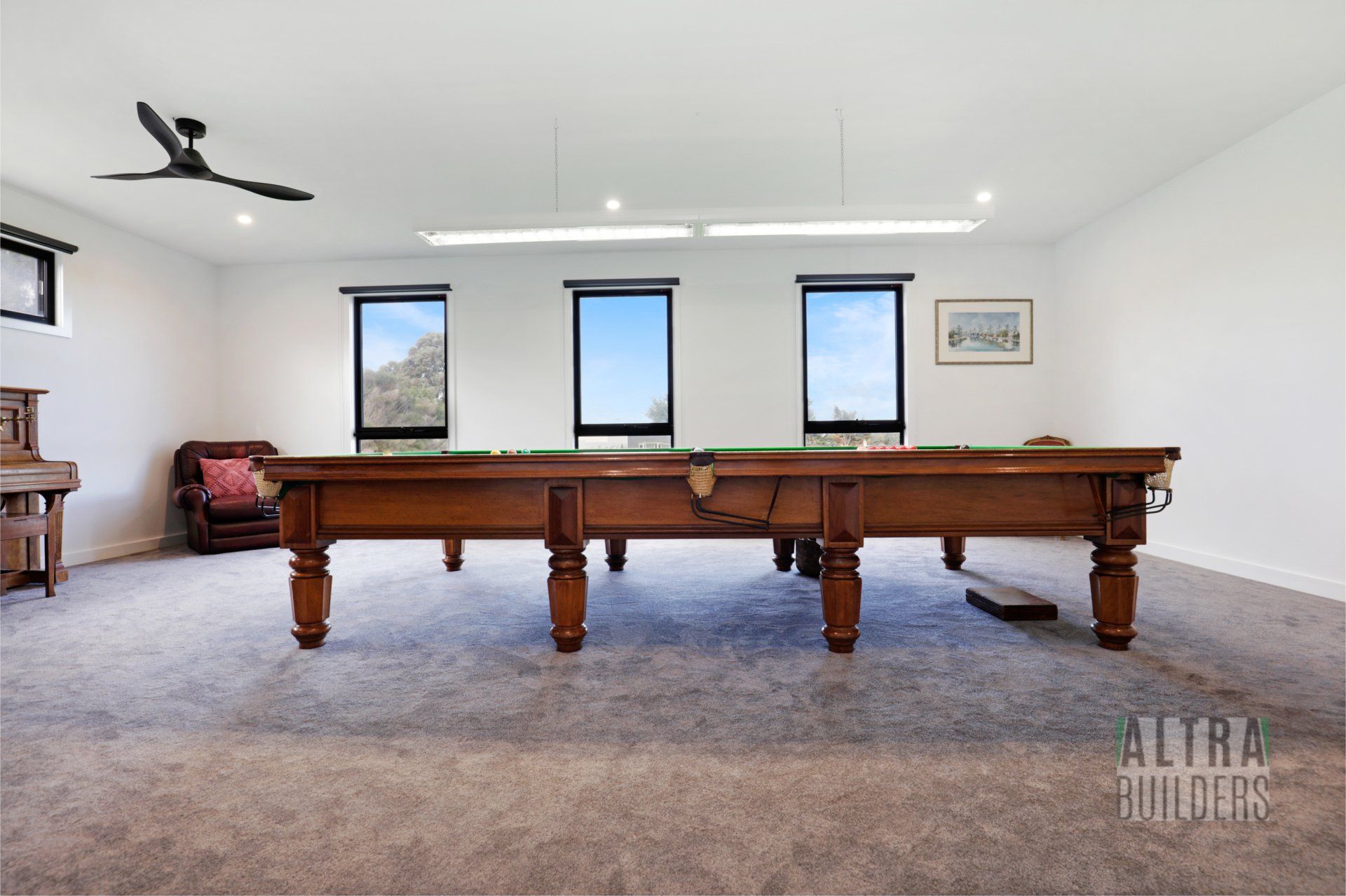 A pool table in a room with a ceiling fan