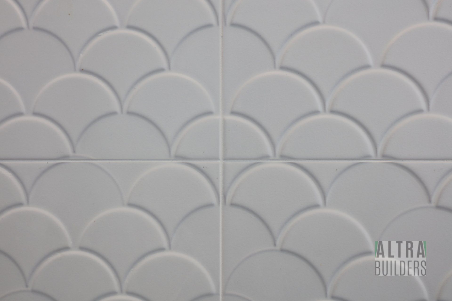 A white tile with a fish scale pattern on it.