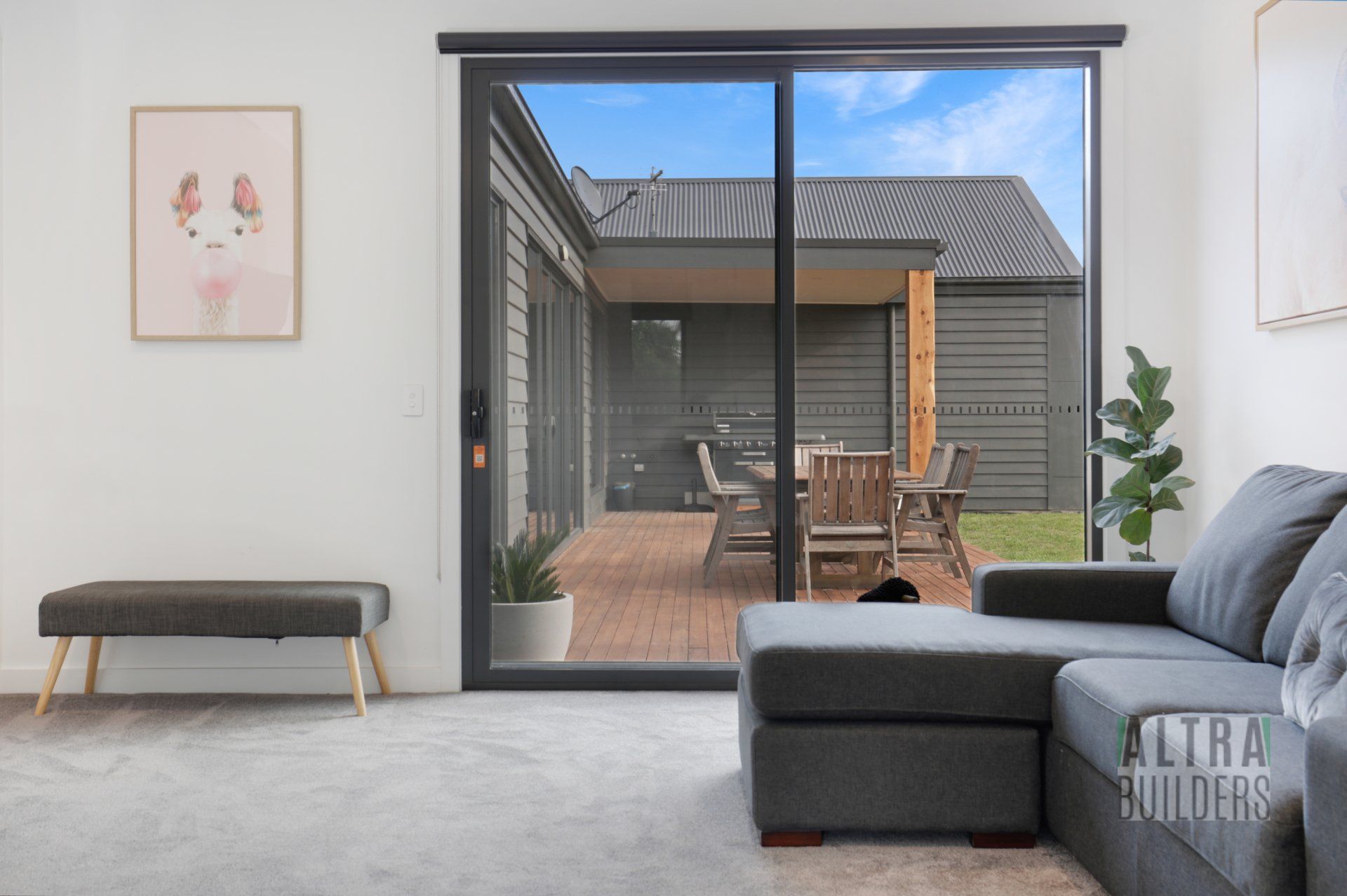 A living room with a couch and a sliding glass door leading to a patio.