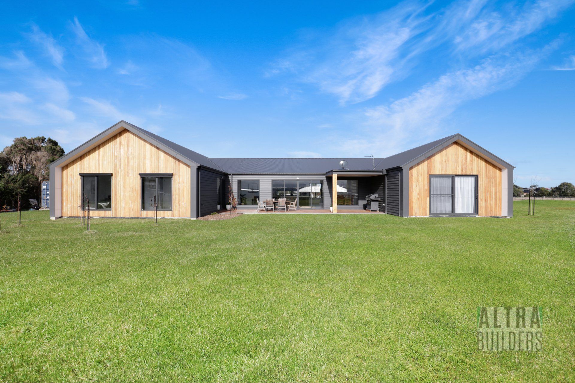 A large house is sitting on top of a lush green field.