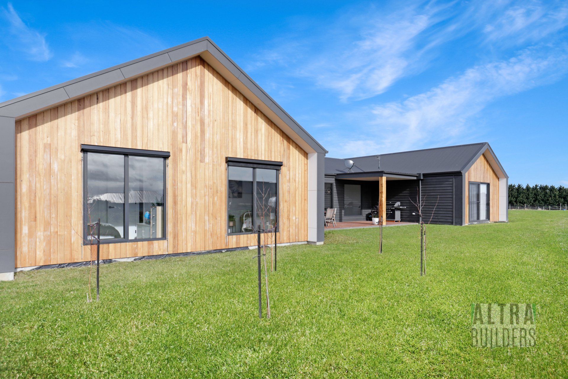 A couple of houses sitting on top of a lush green field.