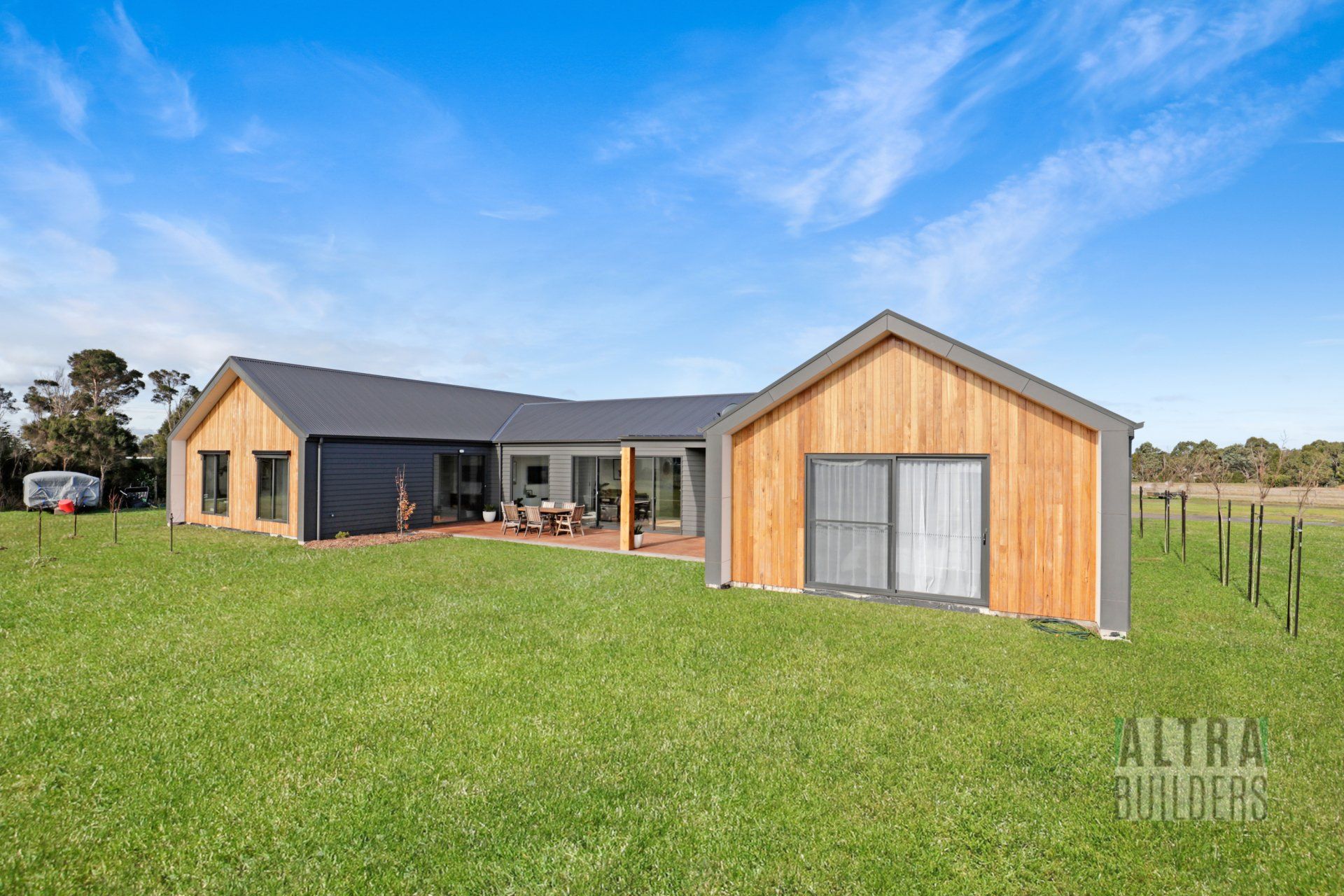 A large house is sitting on top of a lush green field.