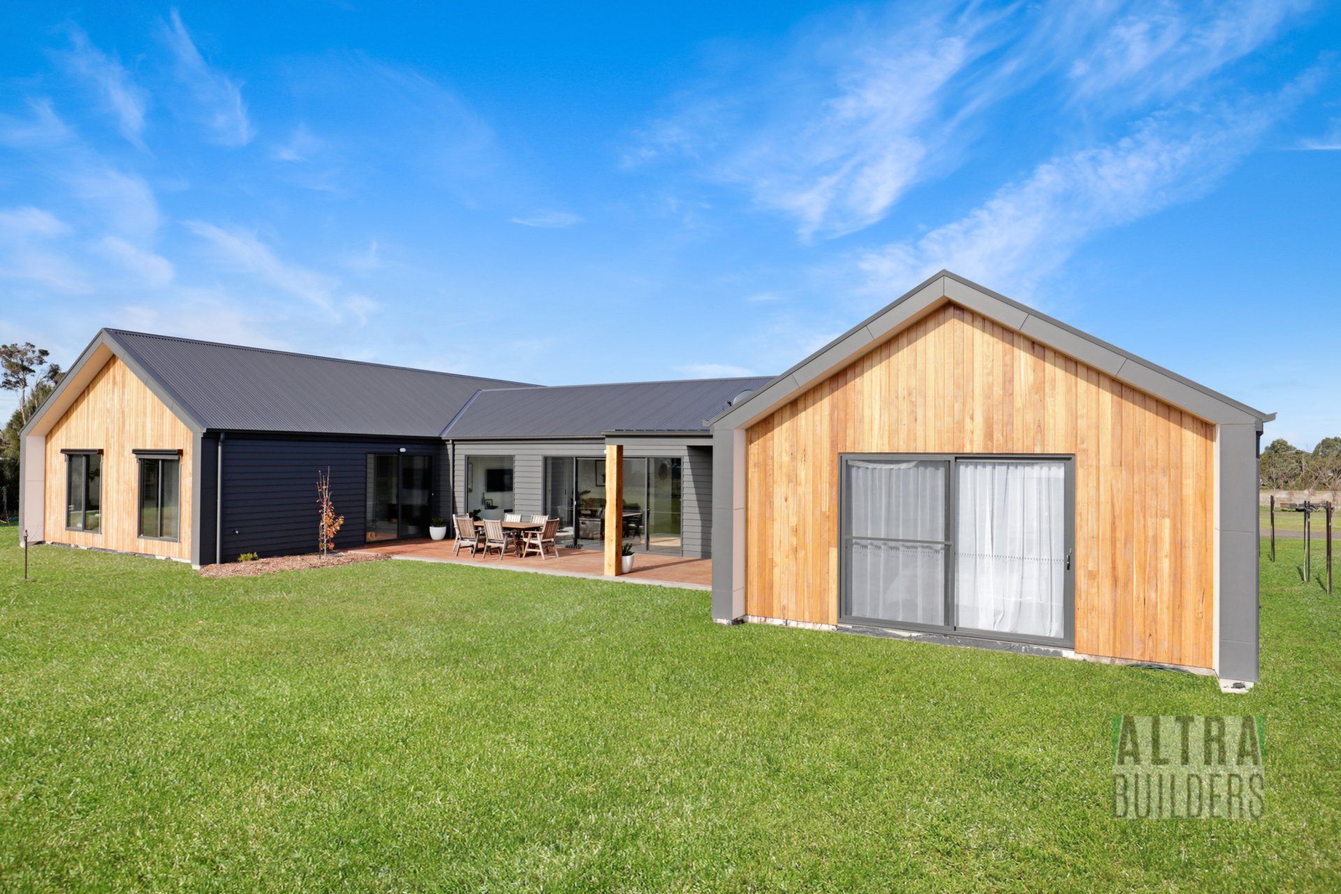 A large house is sitting on top of a lush green field.
