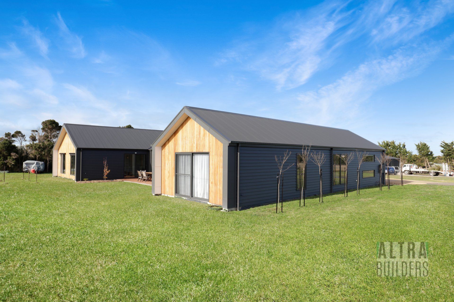 A couple of houses sitting on top of a lush green field.