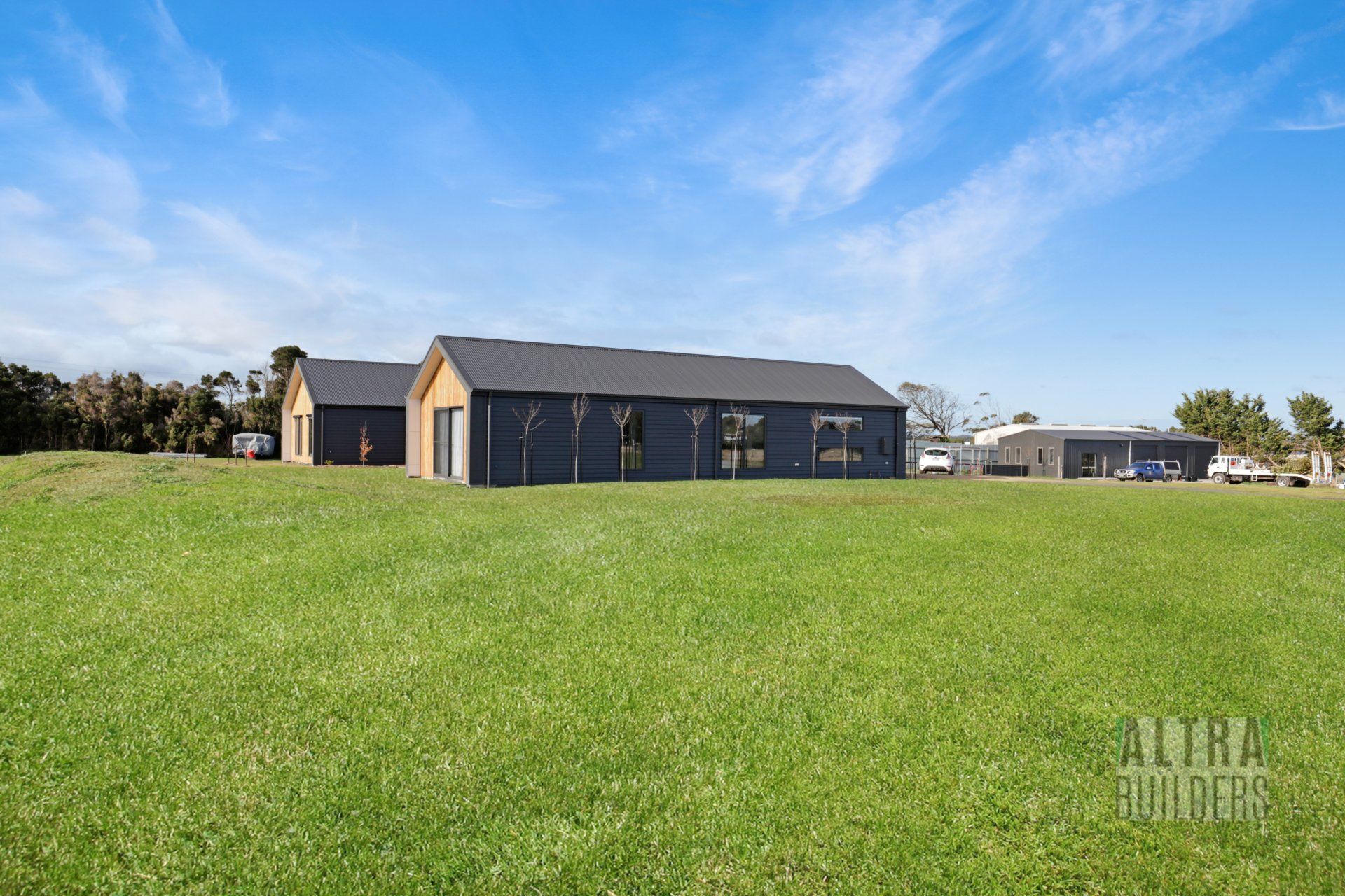 A large house is sitting on top of a lush green field.