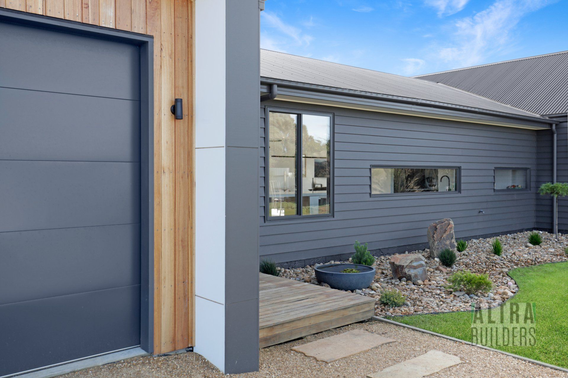 A house with a garage door and a walkway leading to it.