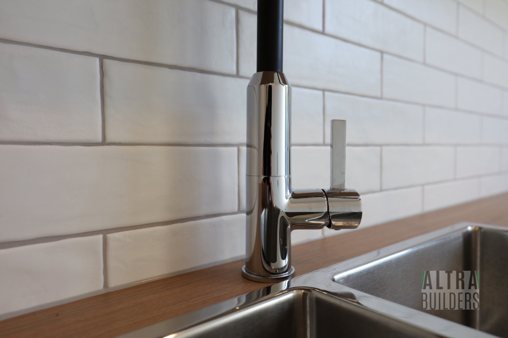 A kitchen sink with a faucet that says aura builders