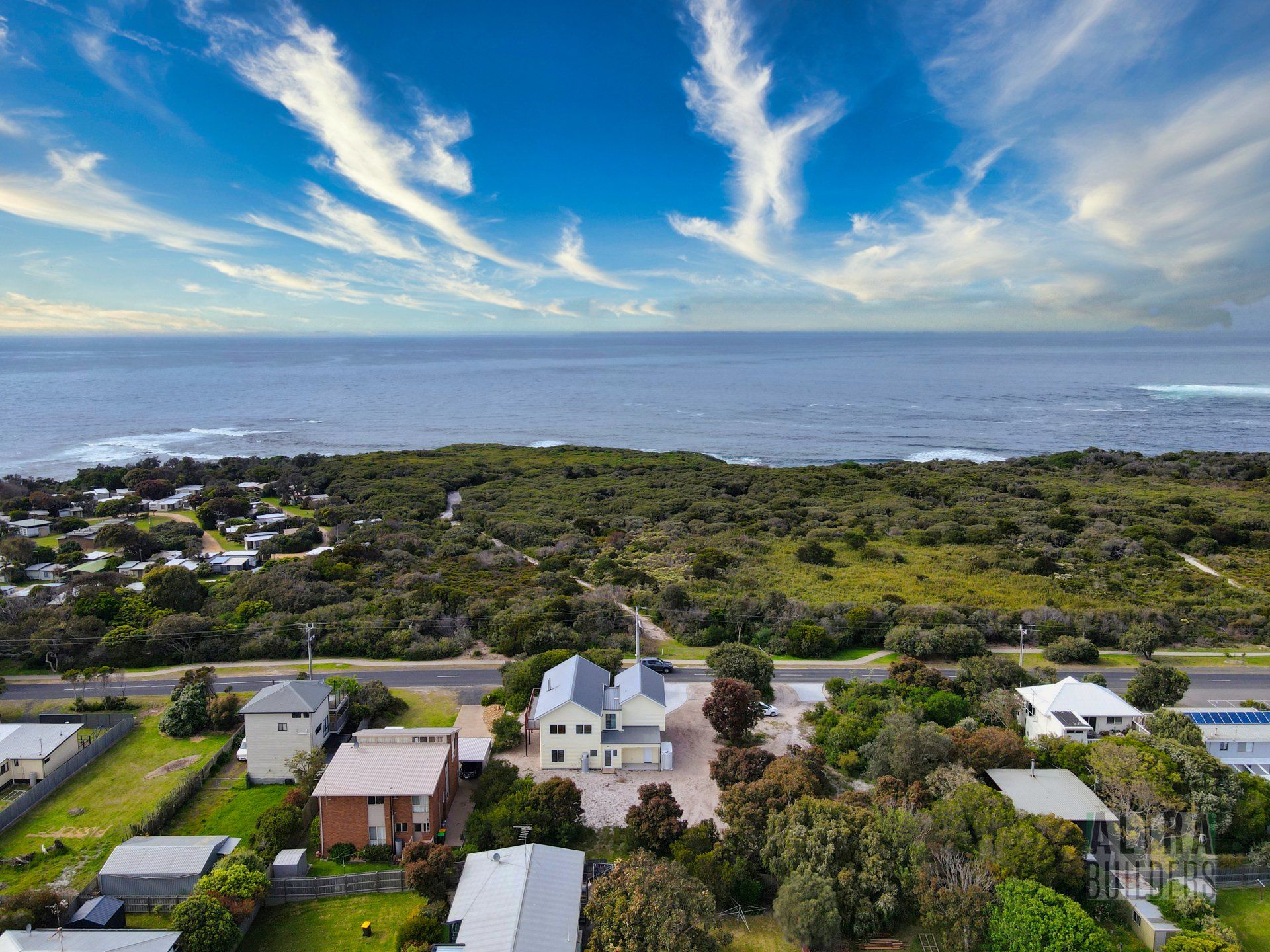 An aerial view of a house next to the ocean