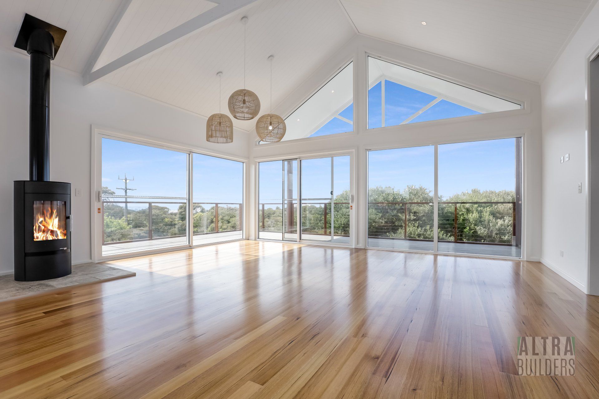 An empty living room with a fireplace and lots of windows