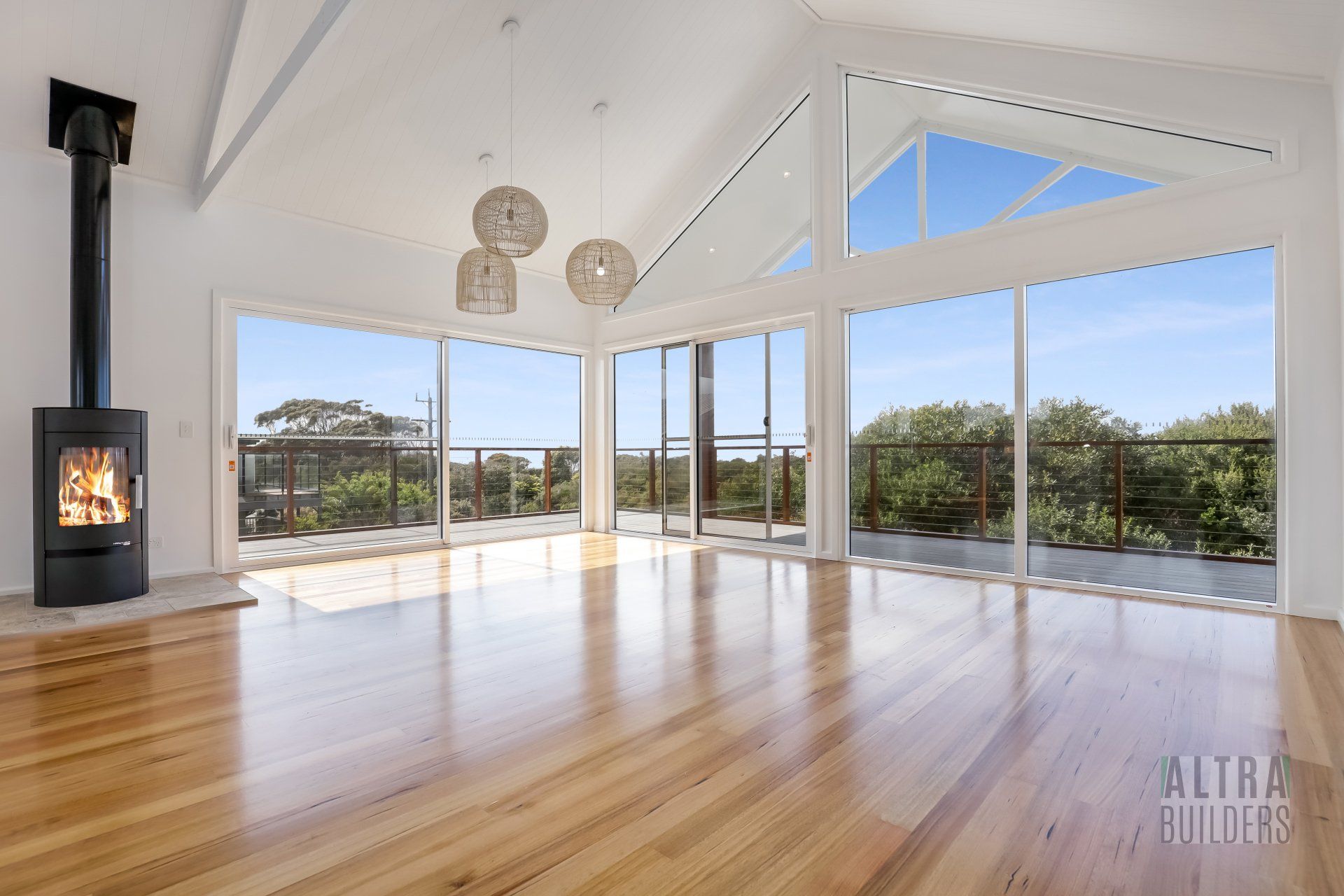 An empty living room with hardwood floors and a fireplace.