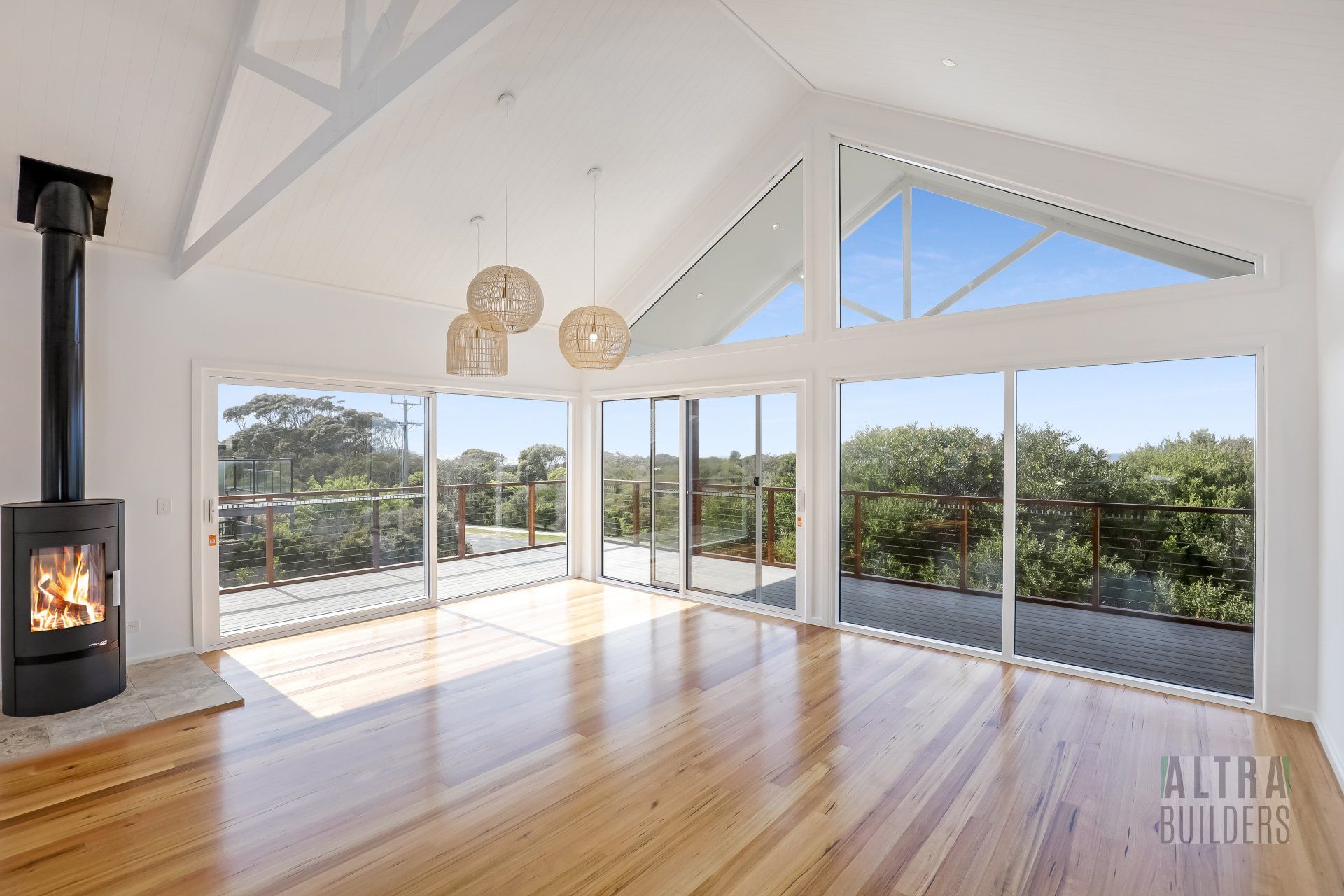 An empty living room with a fireplace and lots of windows