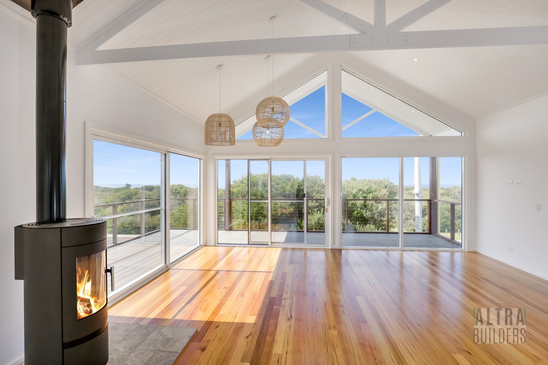 An empty living room with hardwood floors and a fireplace.