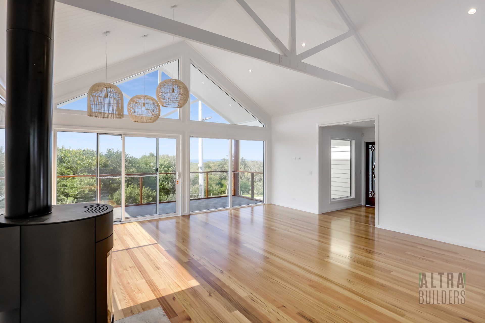 An empty living room with hardwood floors and a fireplace.