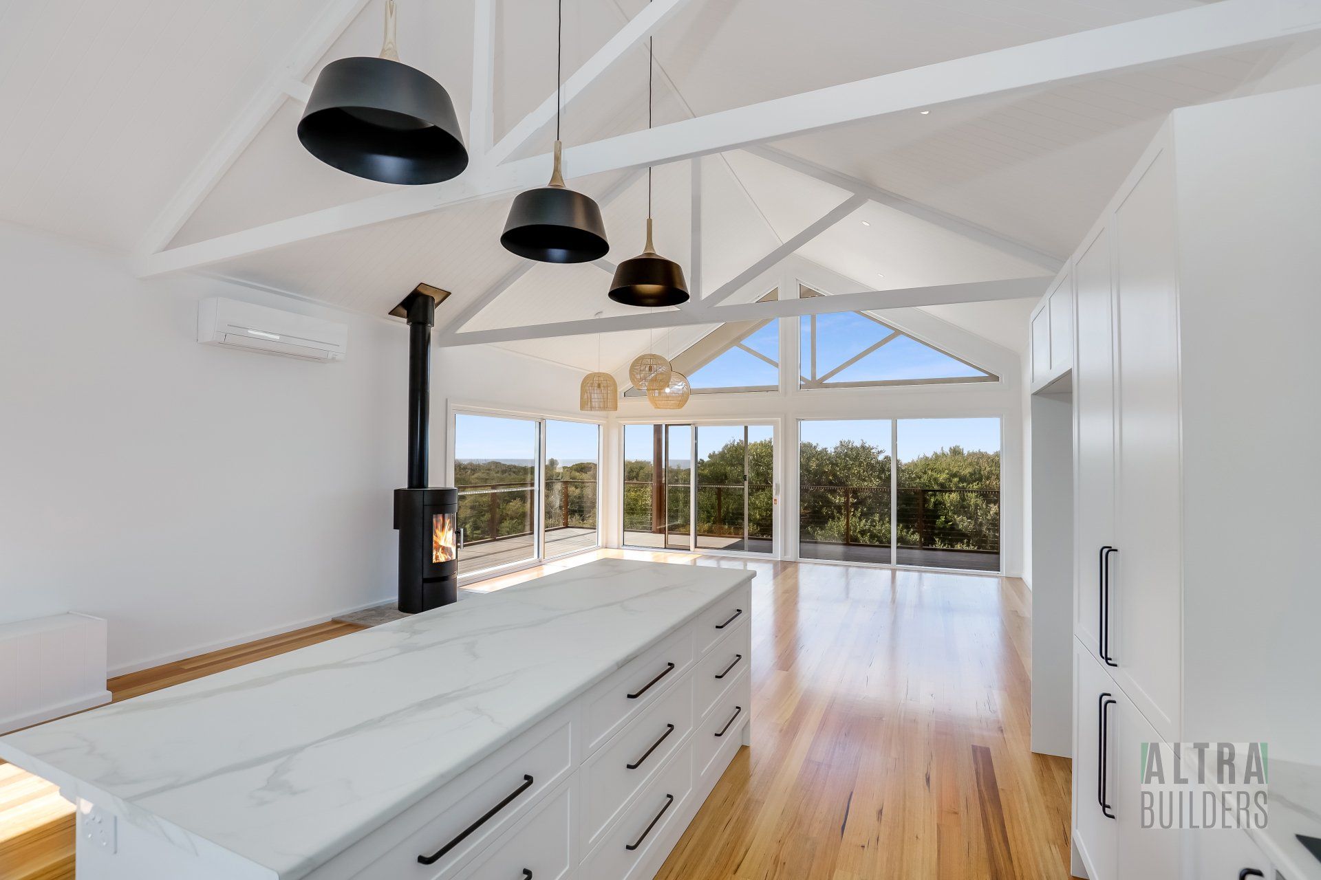 A kitchen with white cabinets and a wood stove
