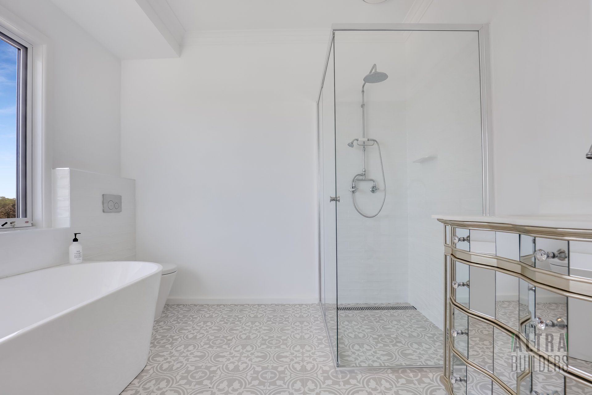 A bathroom with a bathtub , shower , and mirrors.