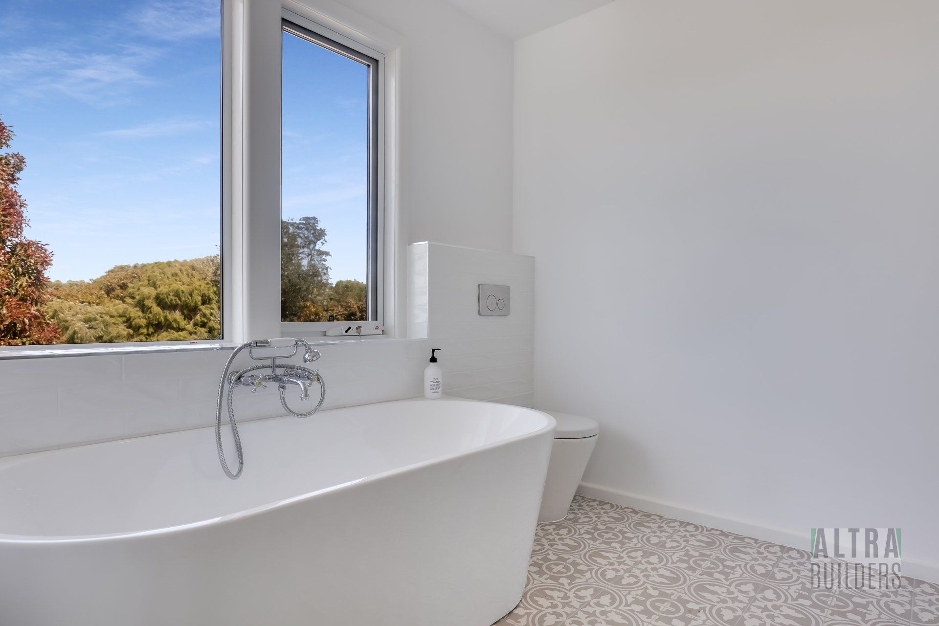 A bathroom with a bathtub , toilet , and window.