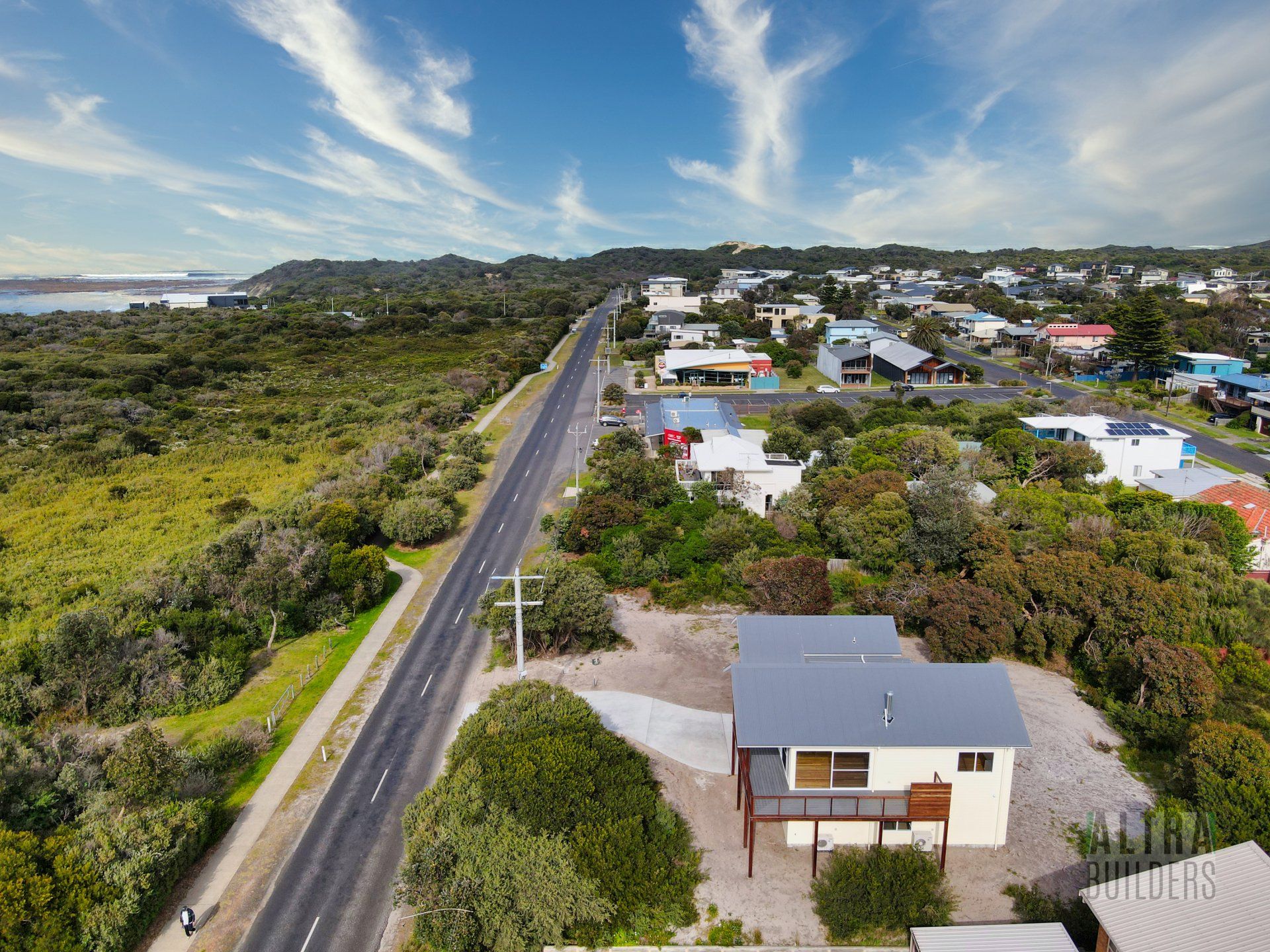 An aerial view of a house next to a road