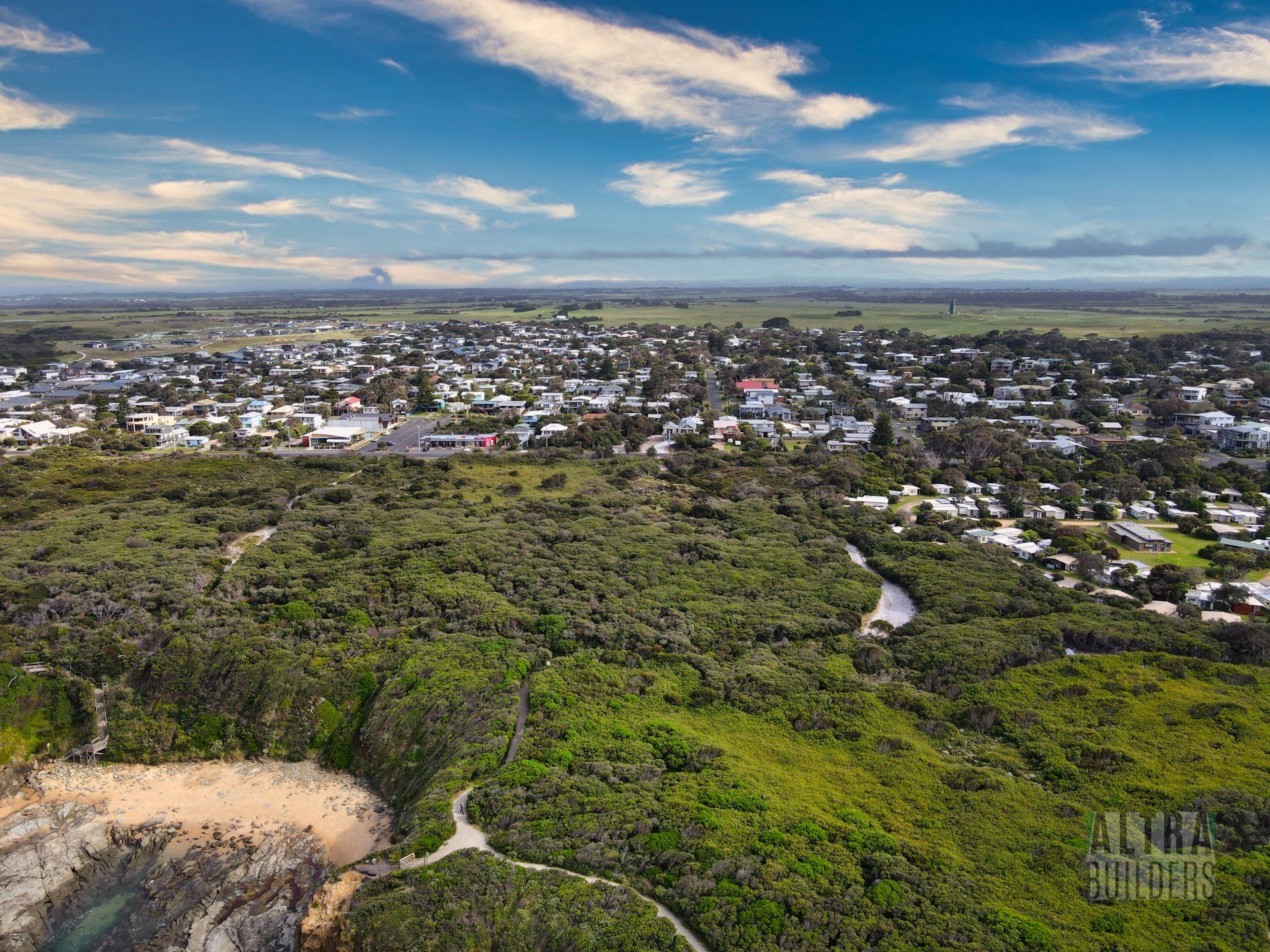 An aerial view of a city surrounded by trees and a river.