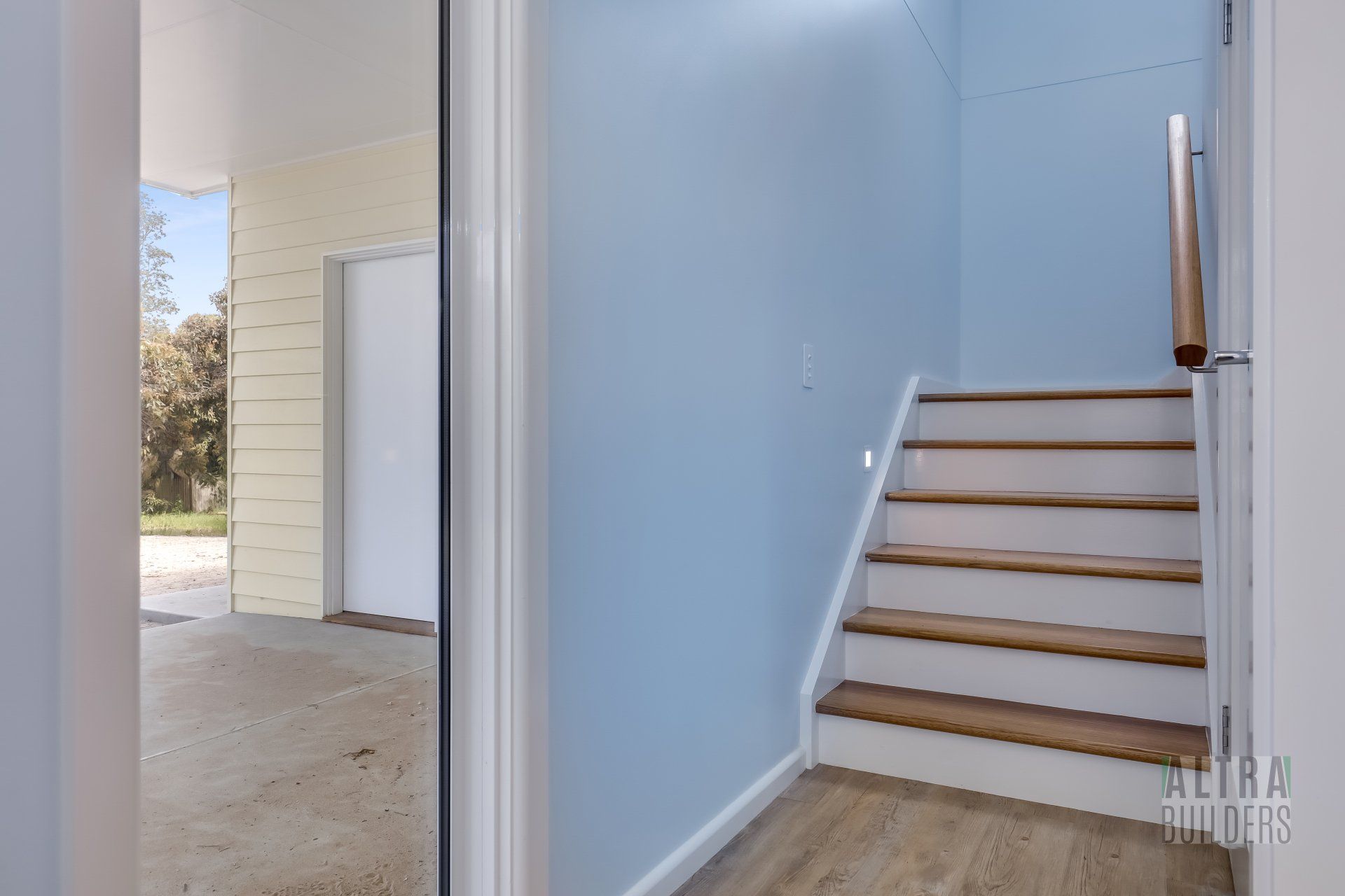 A hallway with stairs leading up to the second floor of a house.