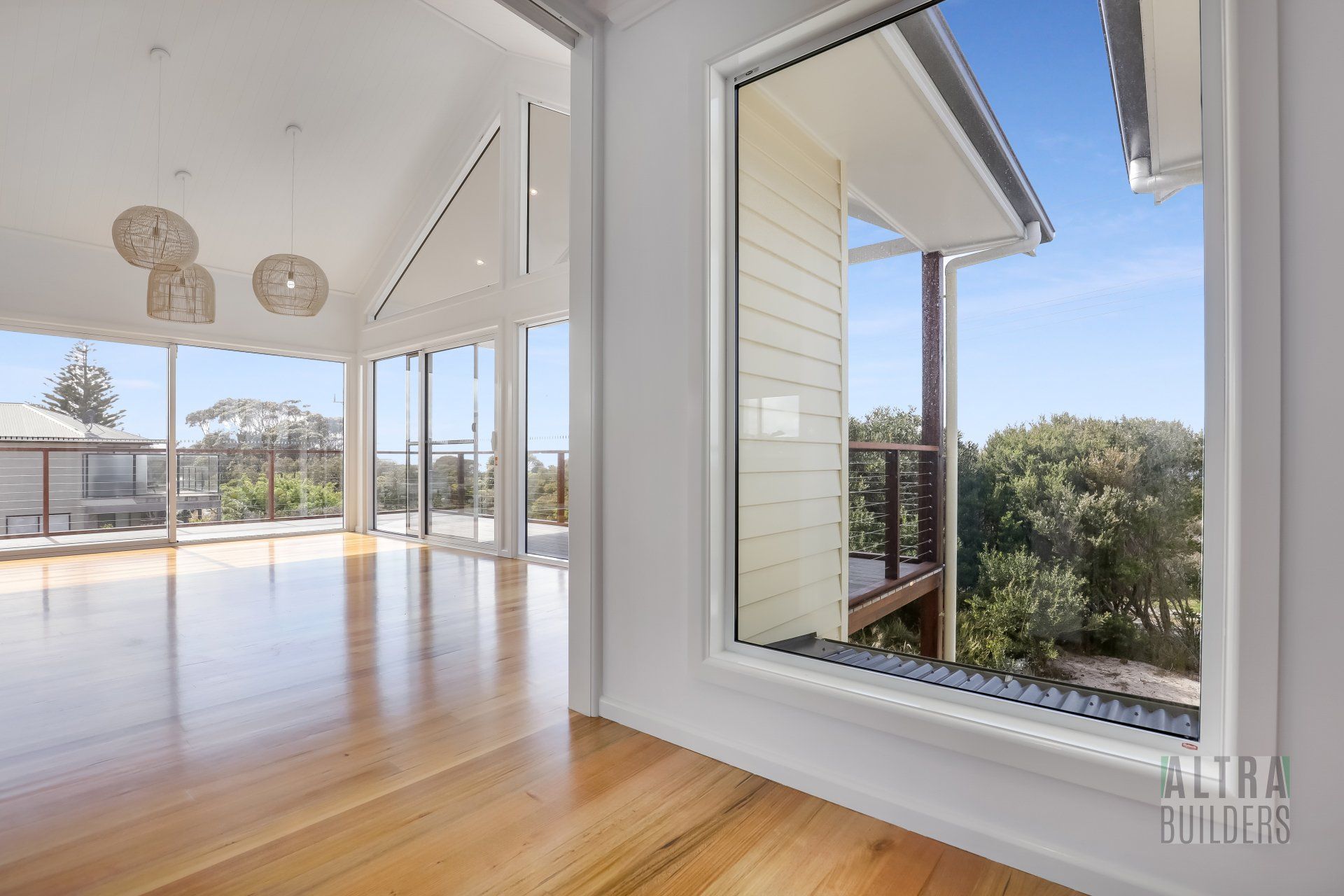 An empty room with hardwood floors and a large window.