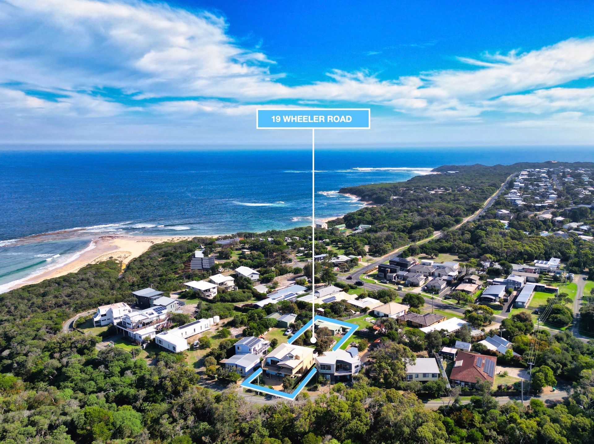 Aerial view of a coastal neighborhood with a light blue outline highlighting a property near a beach and ocean.