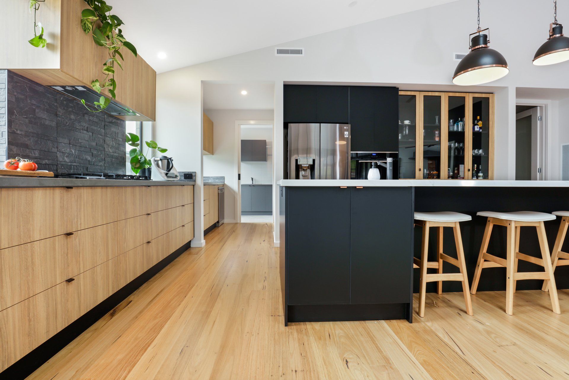 A kitchen with black cabinets and wooden floors