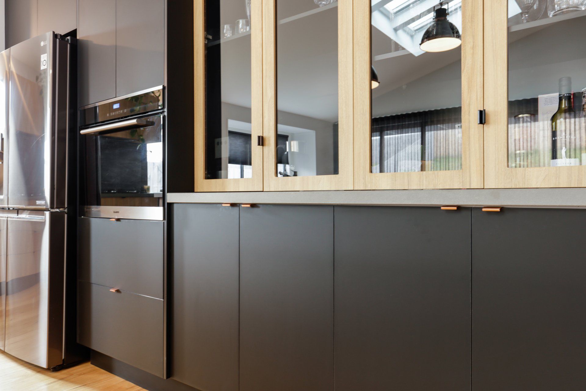 A kitchen with black cabinets and stainless steel appliances.