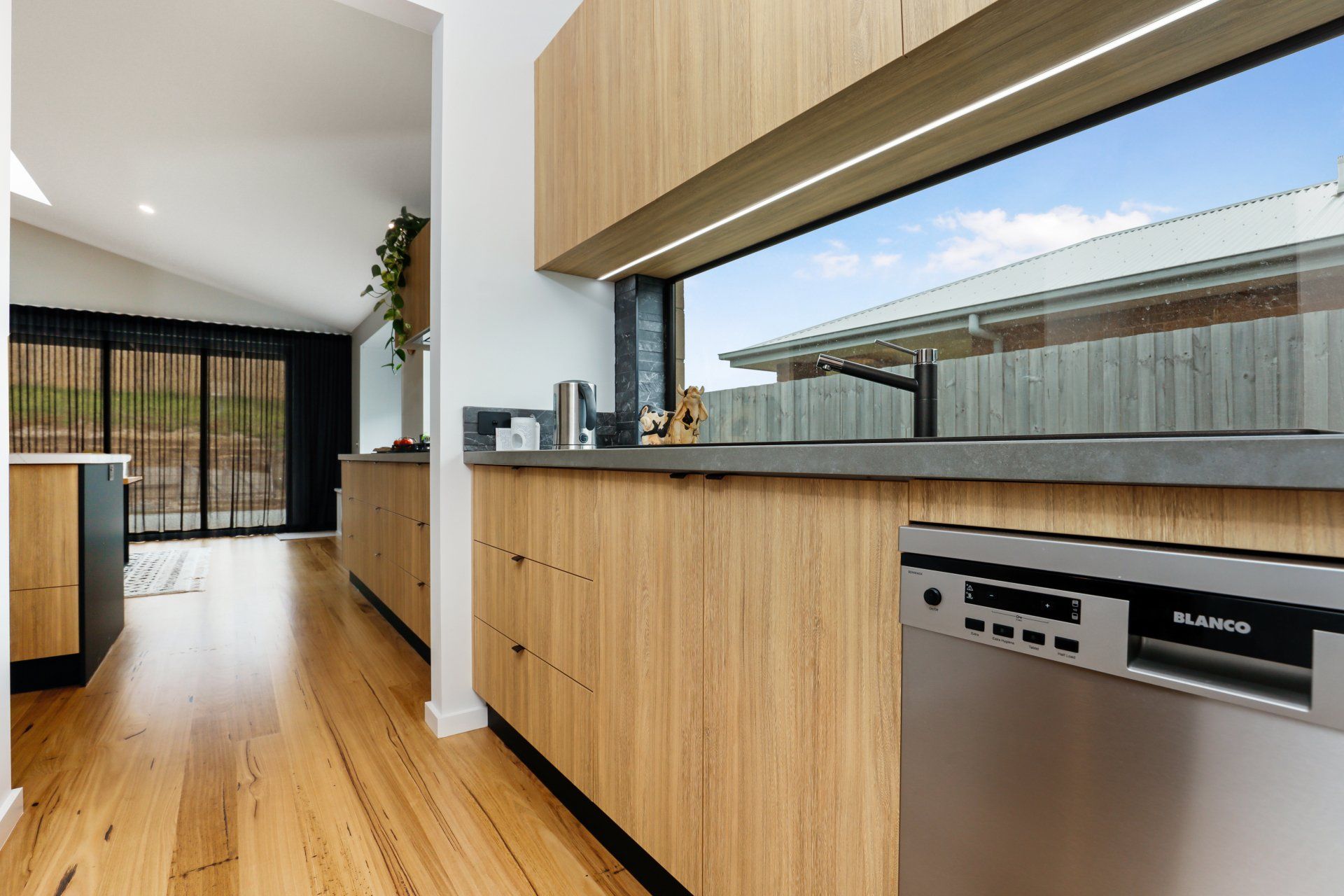 A kitchen with wooden cabinets and a stainless steel dishwasher.