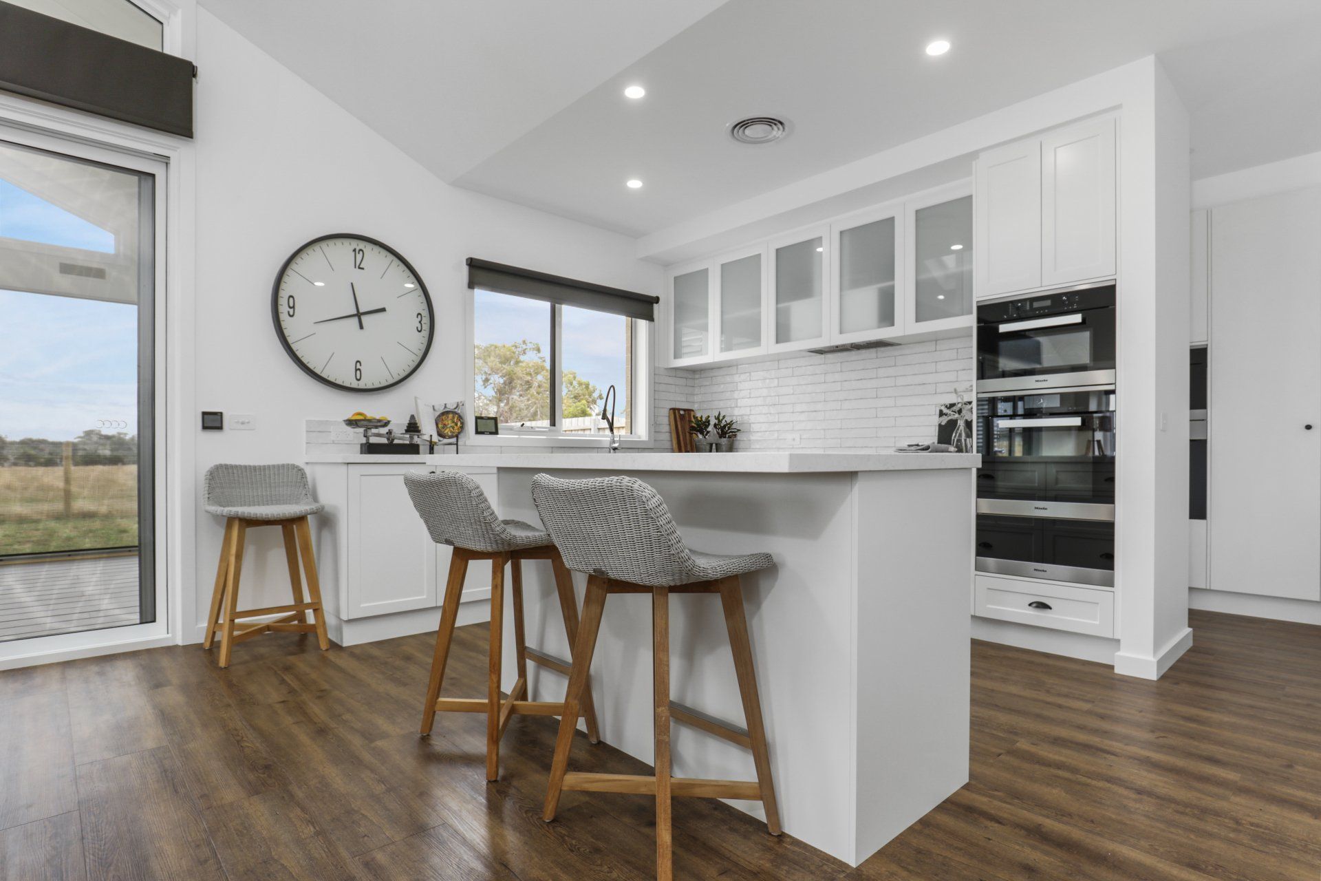There is a clock on the wall above the kitchen island.