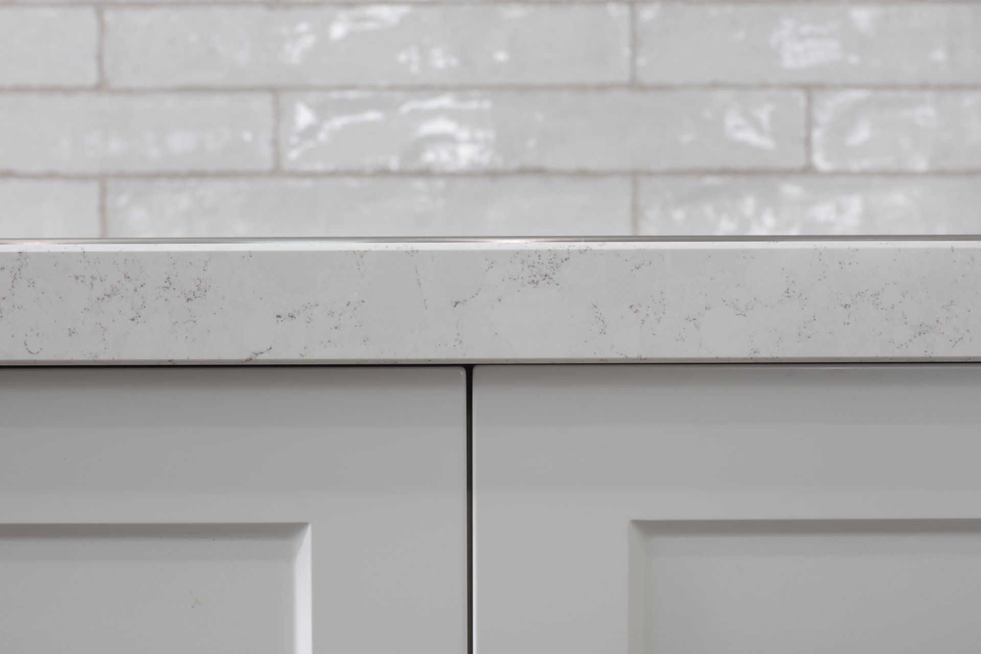 A close up of a white counter top with a brick wall in the background.