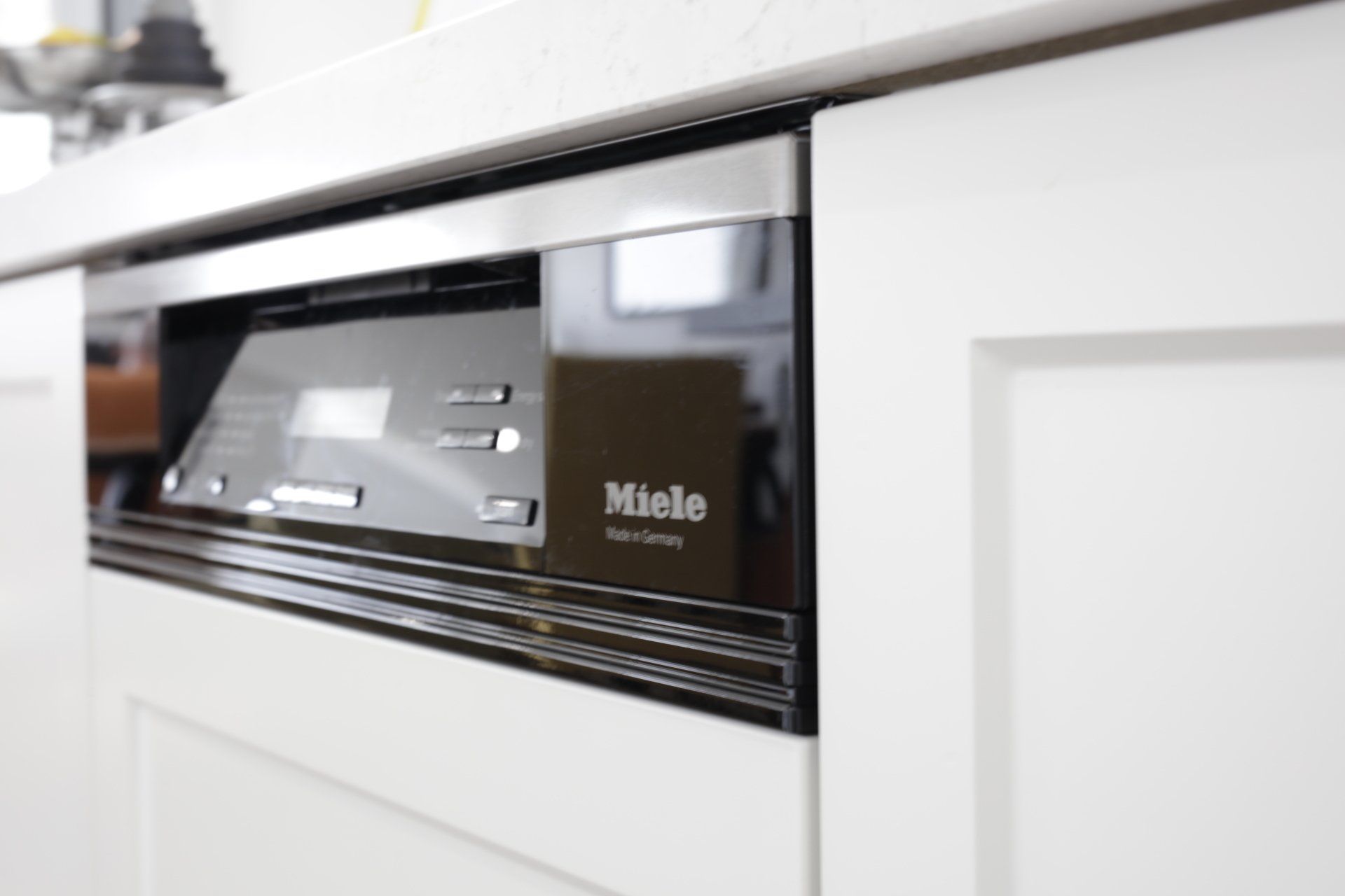 A close up of a miele dishwasher in a kitchen