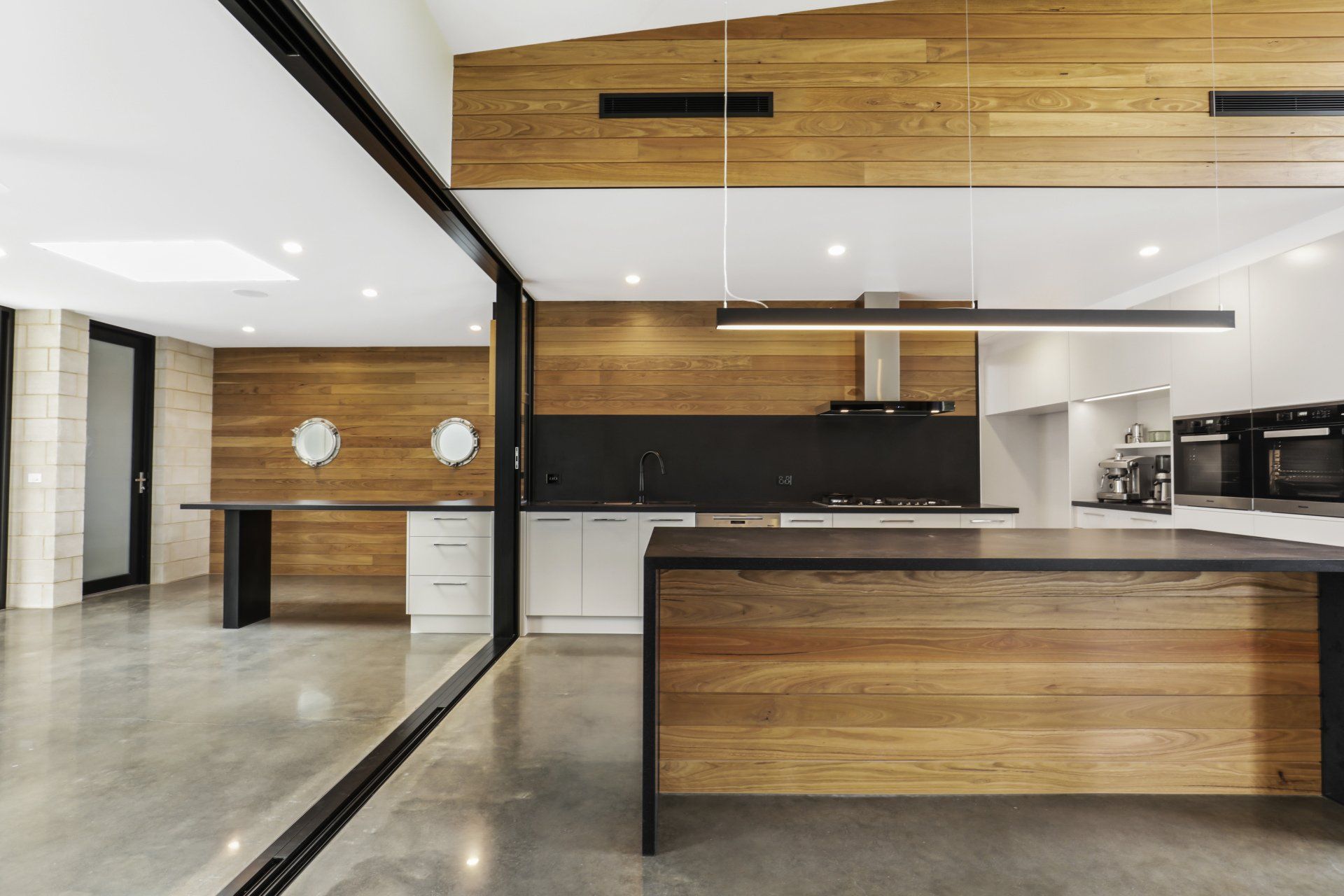 A kitchen with wooden cabinets and a black counter top.