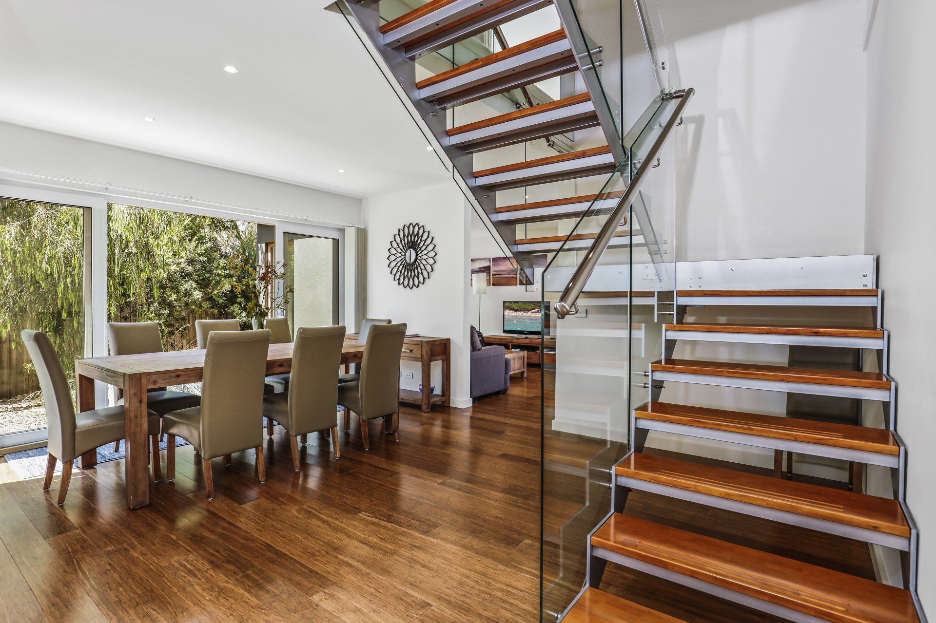 A dining room with a table and chairs and a staircase leading up to the second floor.
