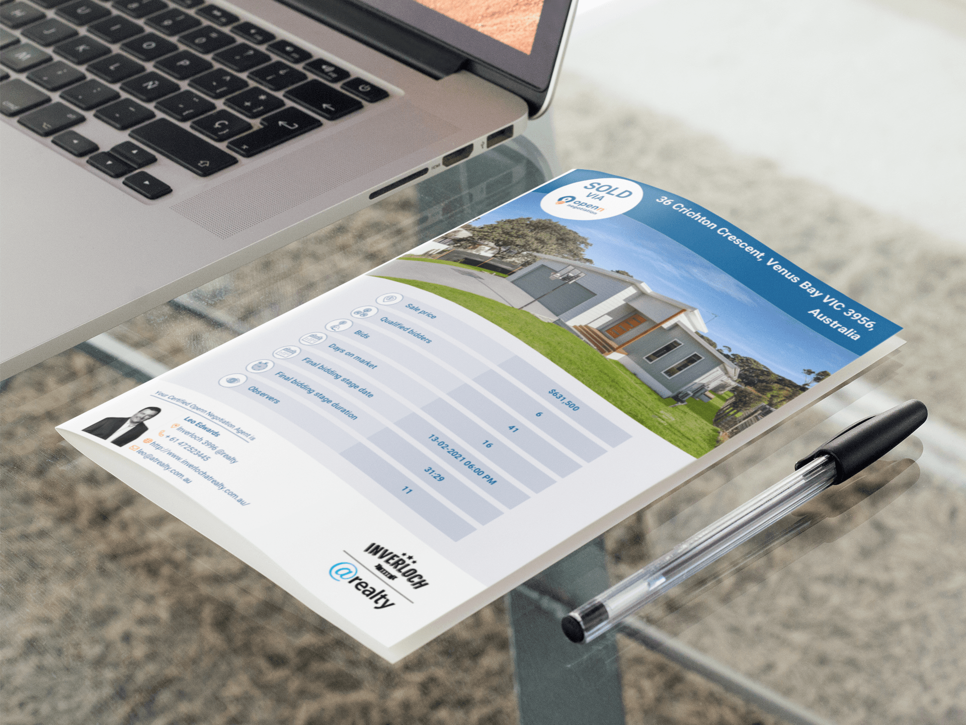 A piece of paper is sitting on a desk next to a laptop and a pen.