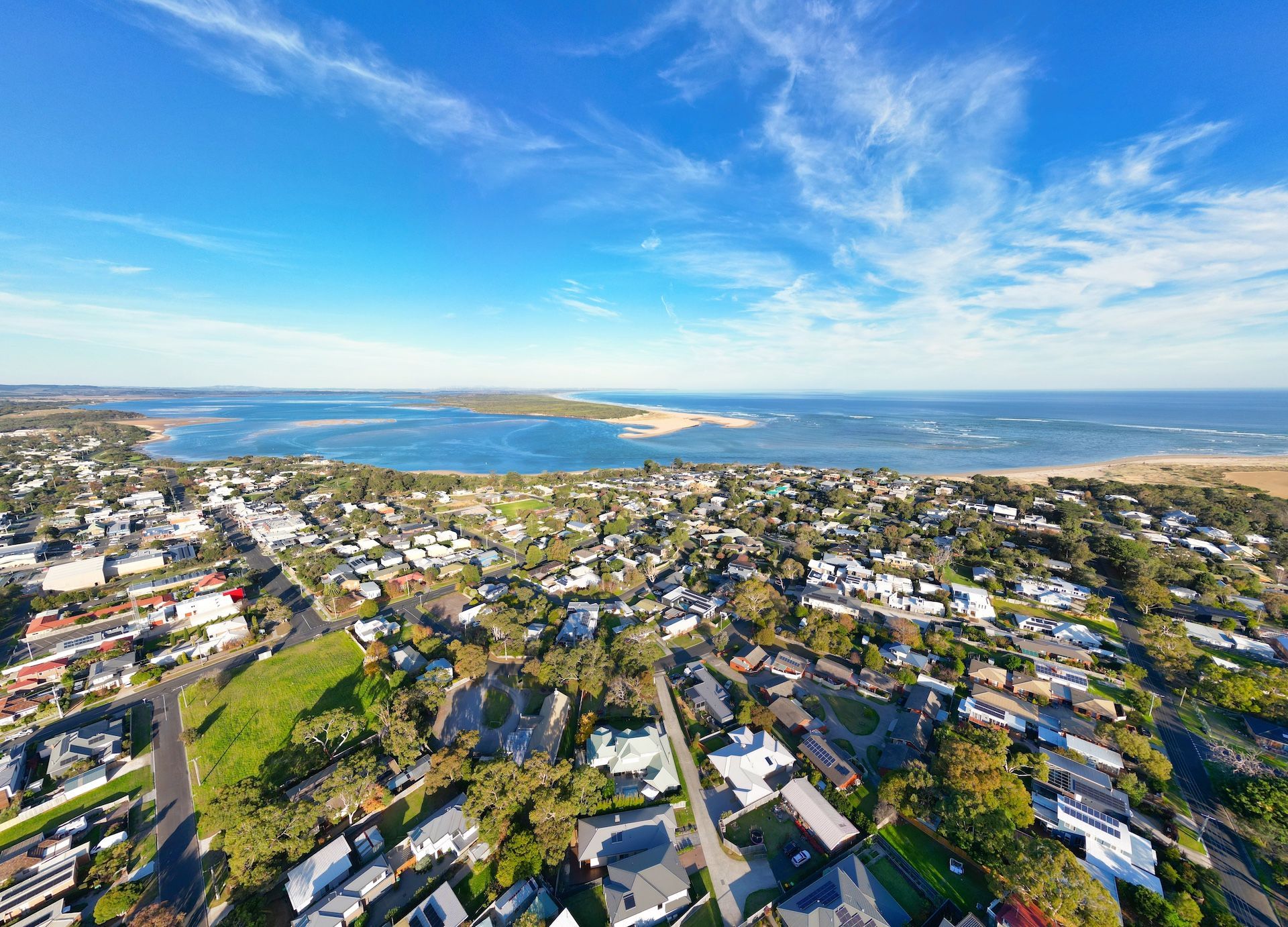 An aerial view of a residential area next to the ocean.