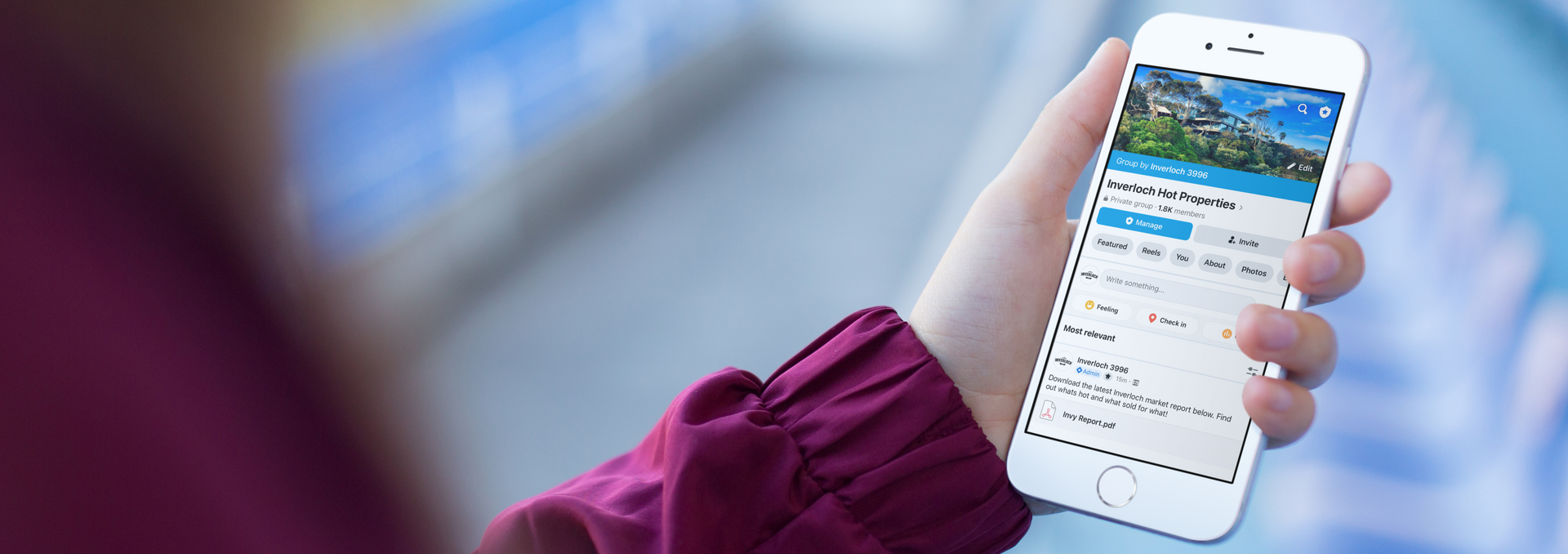 Person holding a white smartphone displaying a travel app, showing a mountain landscape and booking details.