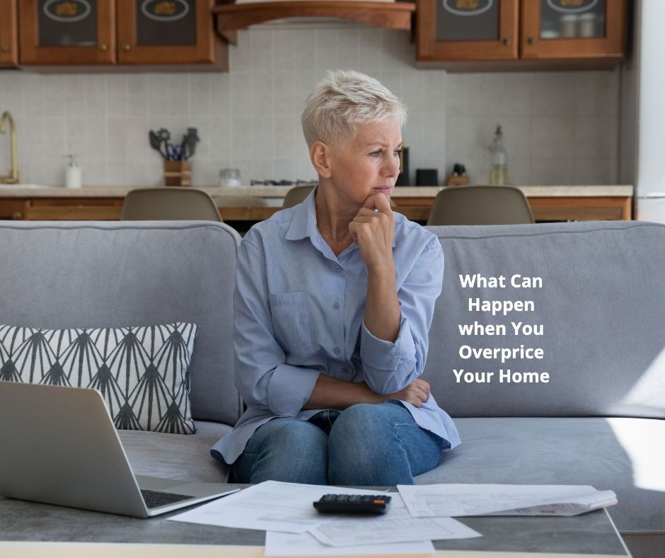 An older woman is sitting on a couch looking at a laptop computer.