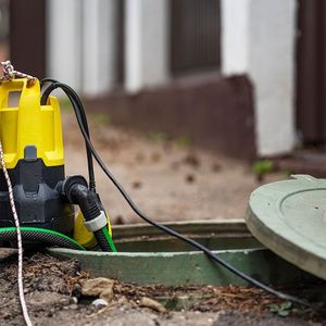 A yellow and black pump is attached to a green hose